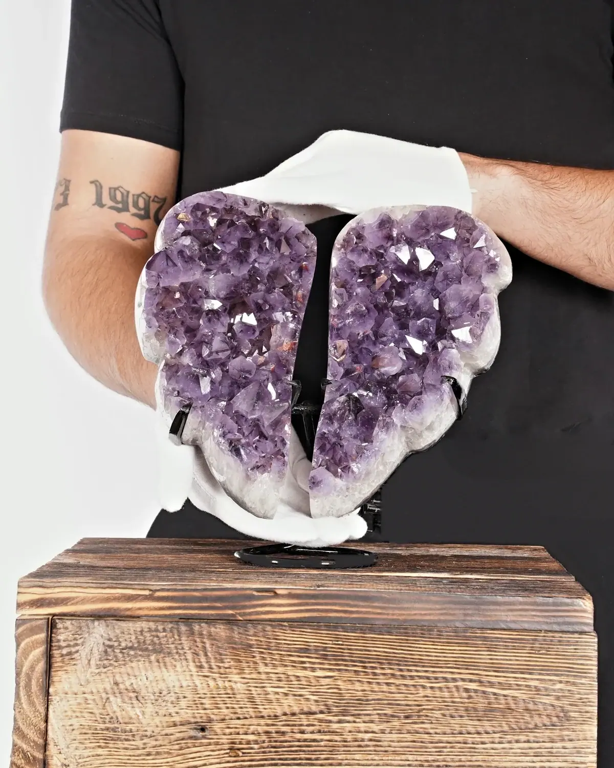 Der beruhigende Amethyst-Flügel in weiss behandschuhten Händen