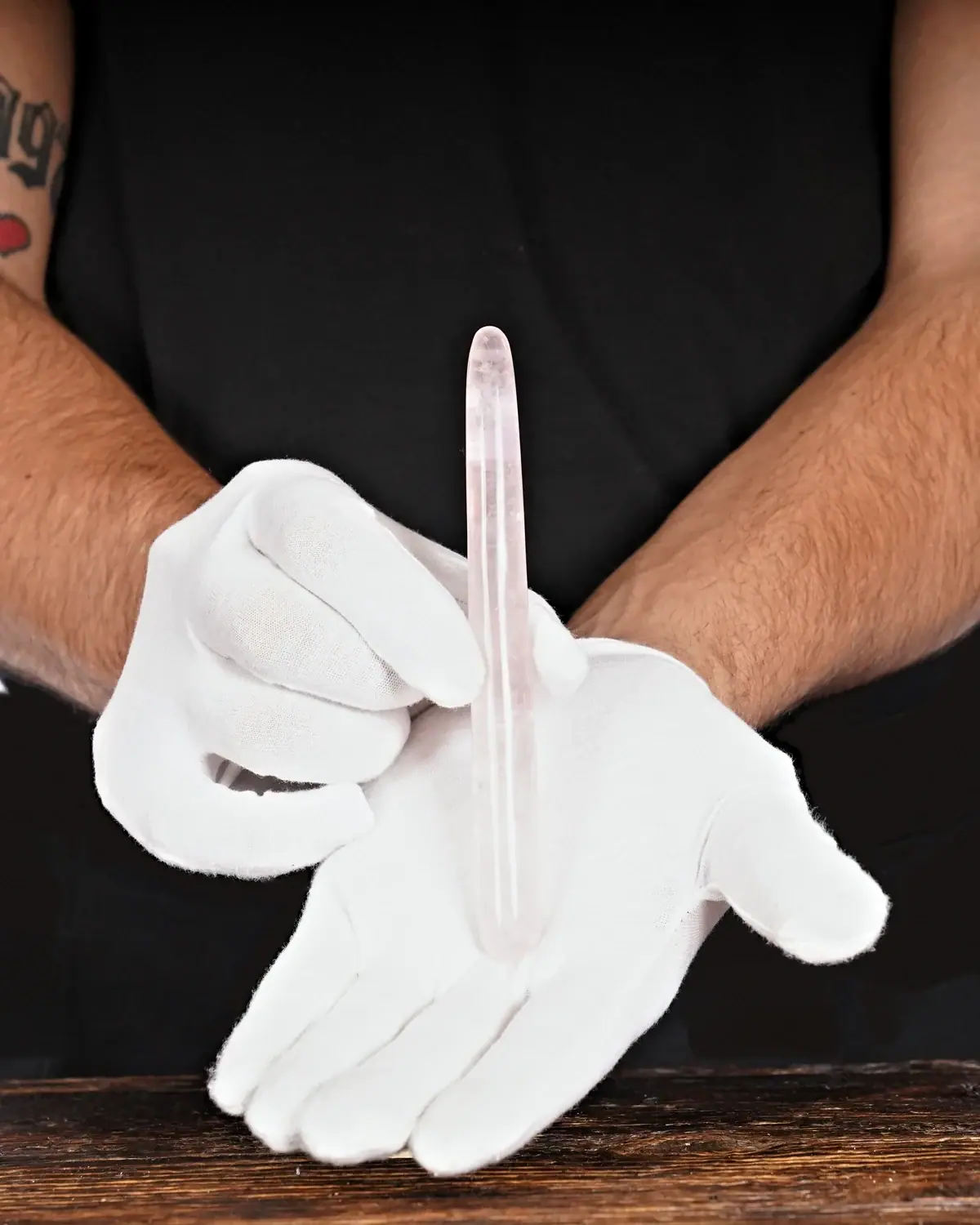 Rosenquarz Massagestäbe Nr. 33 in weiss behandschuhten Händen