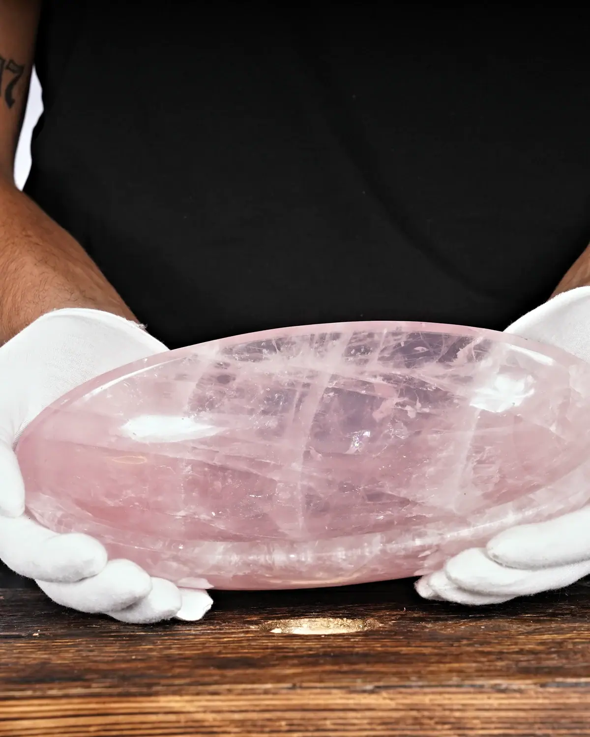 Rosenquarz in weiss behandschuhten Händen