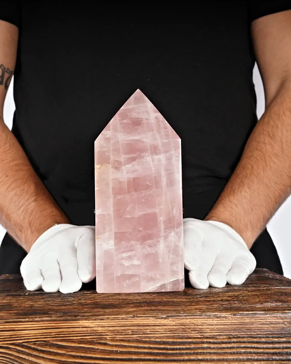 Rosenquarz in weiss behandschuhten Händen