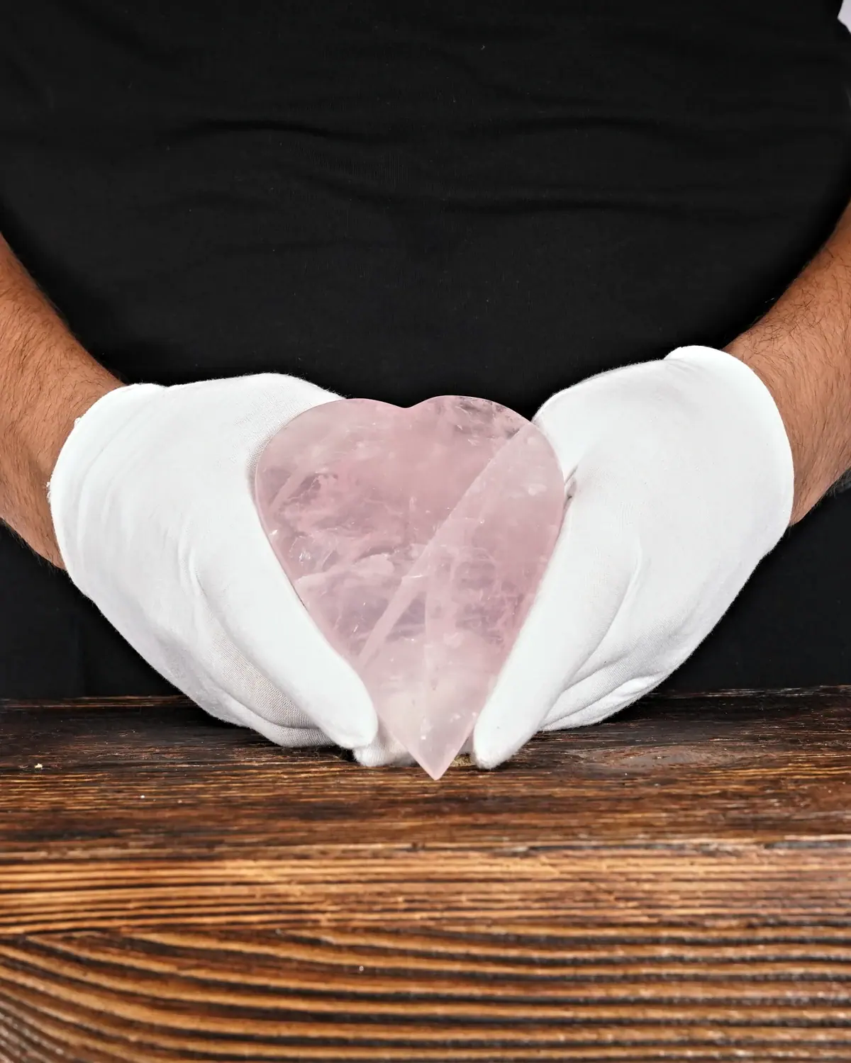 Rosenquarz in weiss behandschuhten Händen