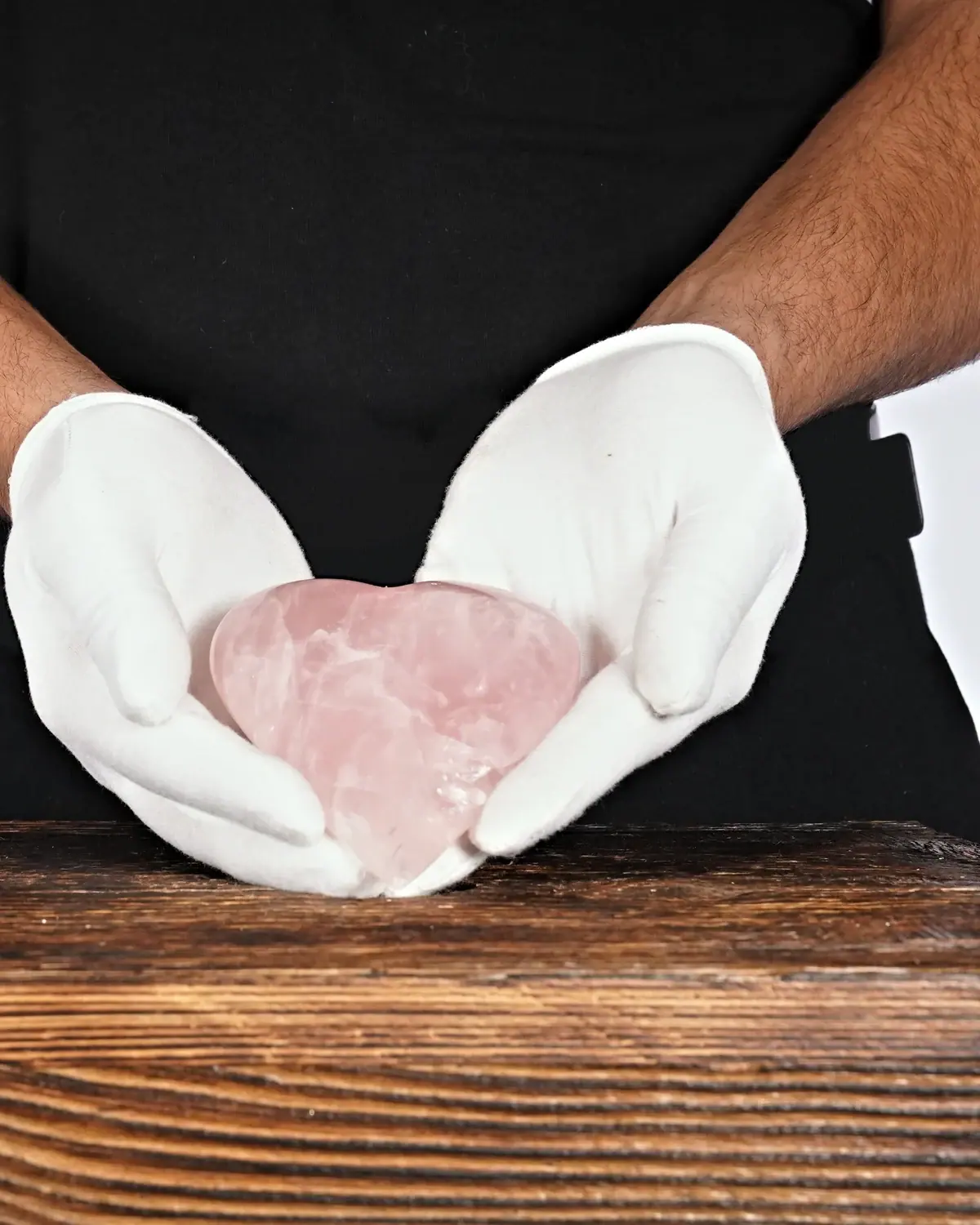 Rosenquarz in weiss behandschuhten Händen