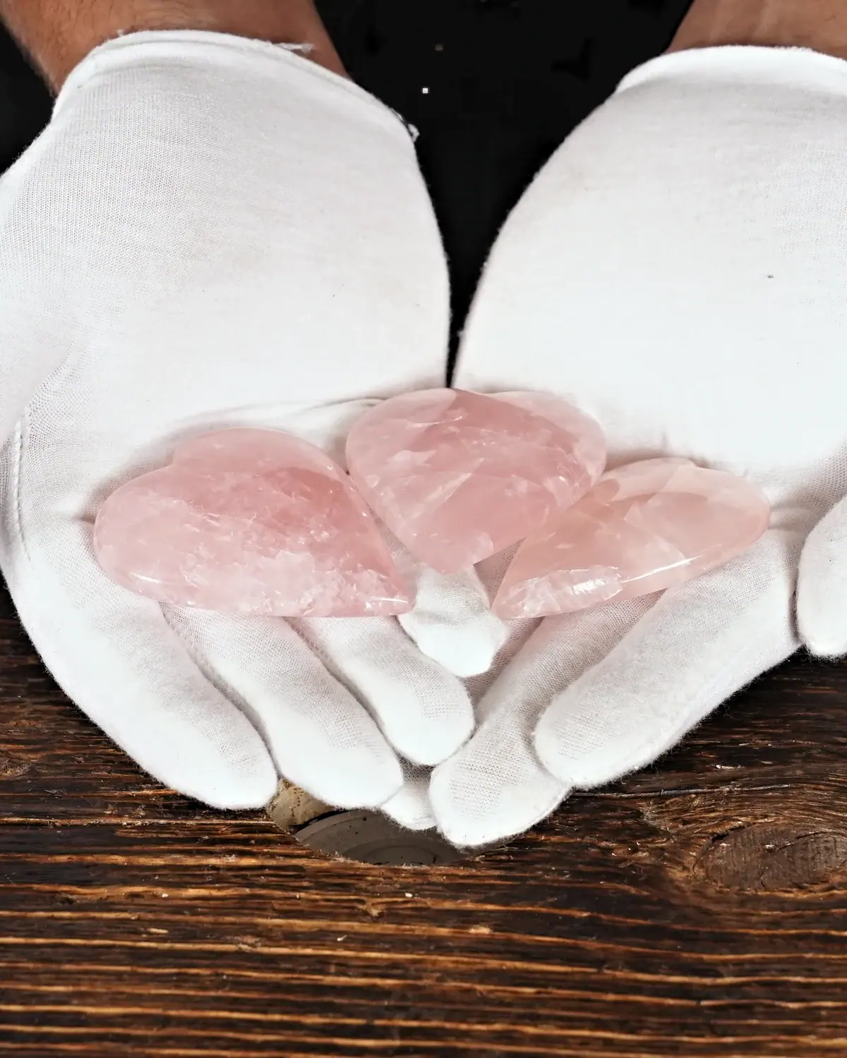 Rosenquarz in weiss behandschuhten Händen