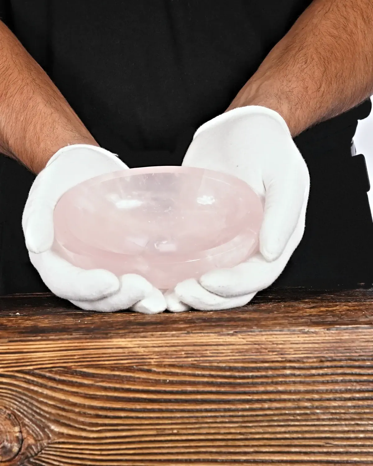 Rosenquarz in weiss behandschuhten Händen