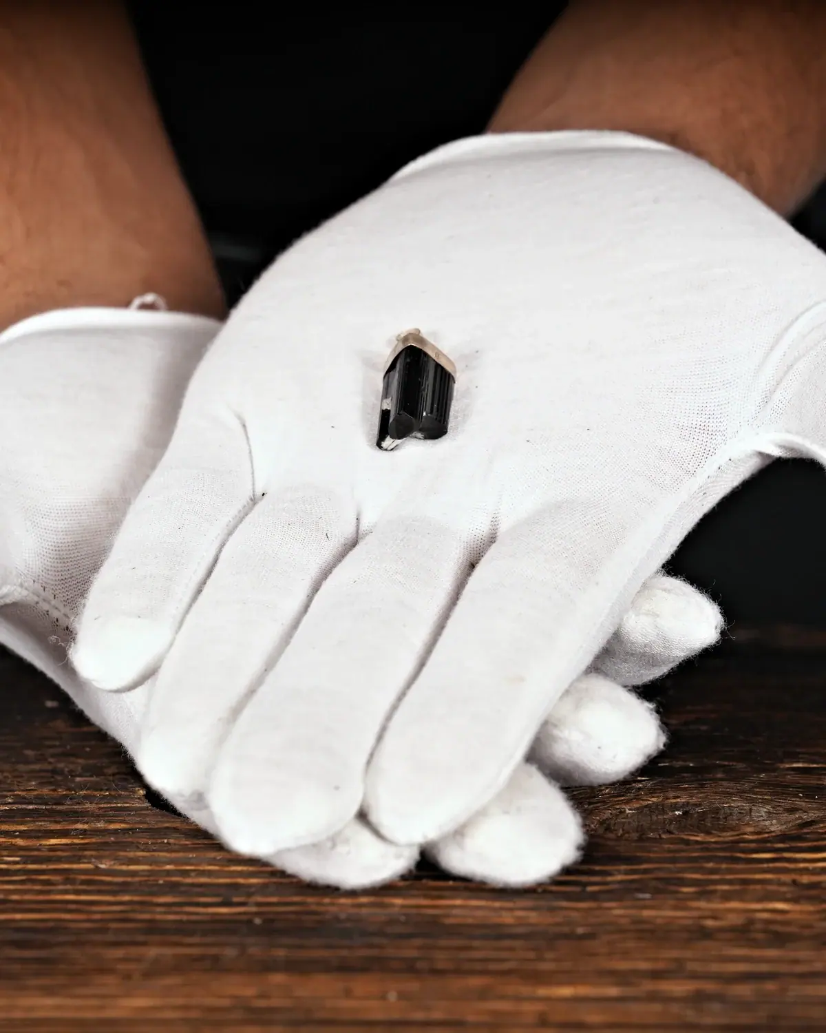 Turmalin in weiss behandschuhten Händen
