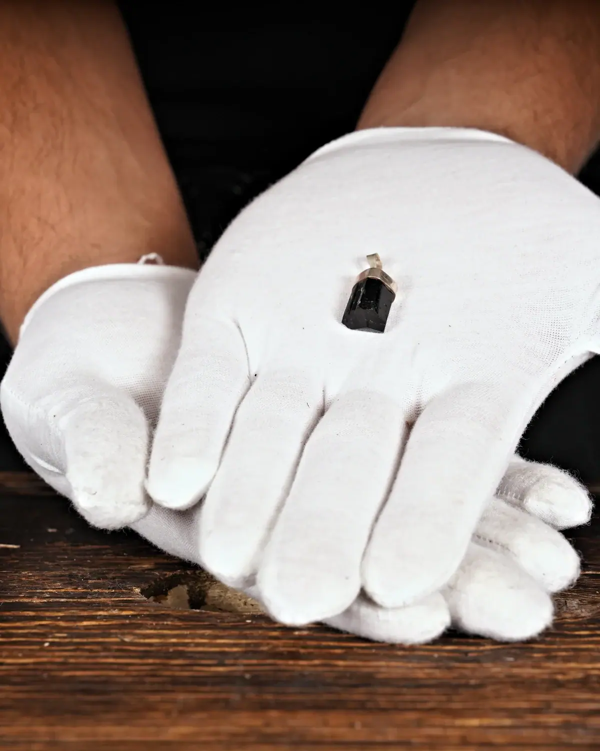 Turmalin in weiss behandschuhten Händen
