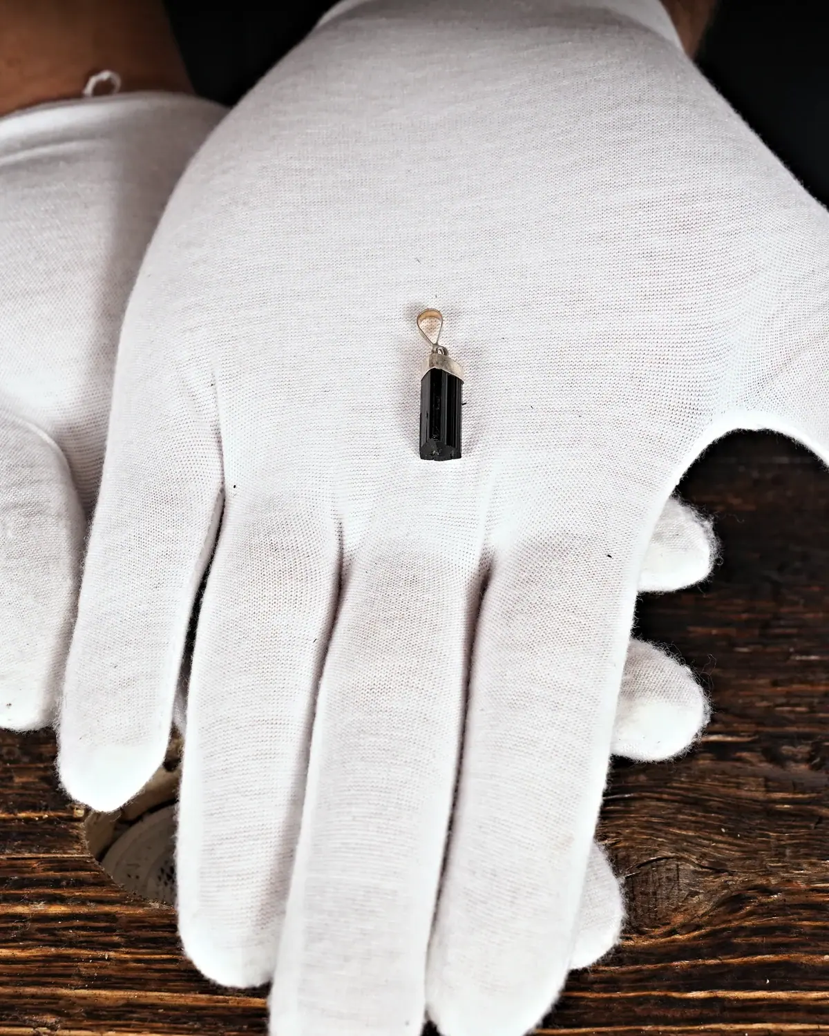 Turmalin in weiss behandschuhten Händen