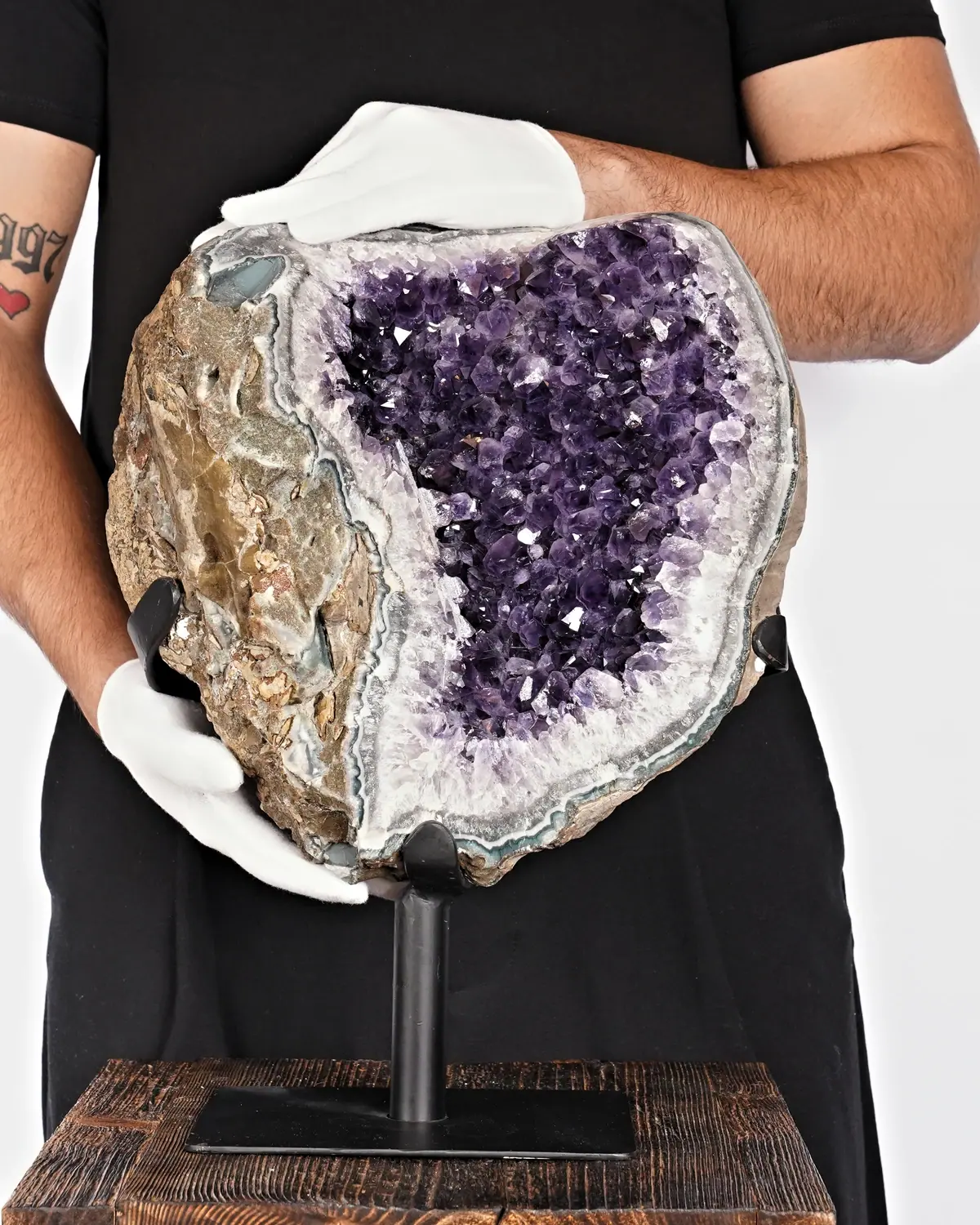 Achat Amethyst auf Ständer Nr. 2 in weiss behandschuhten Händen