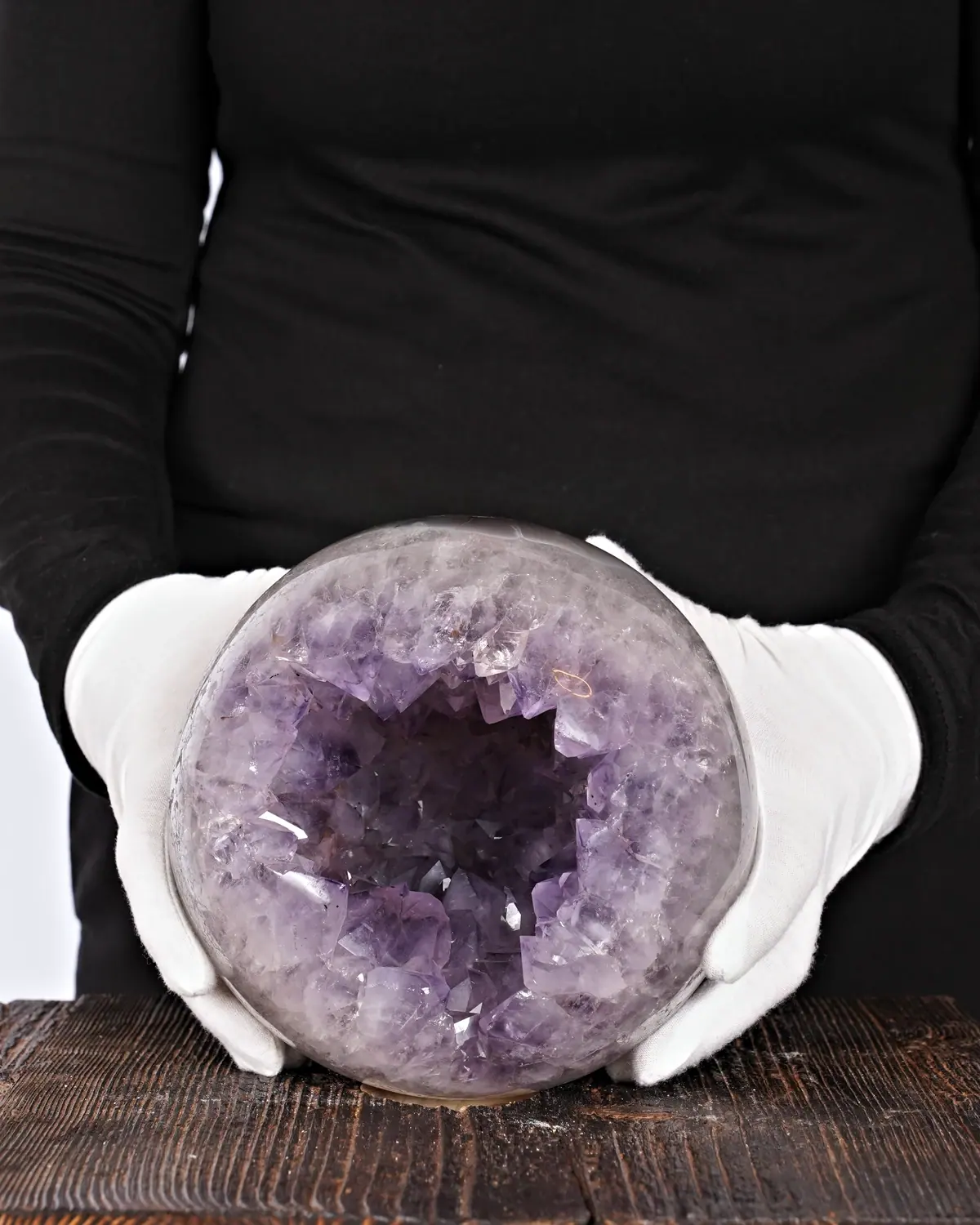 Amethyst Kugel Nr. 197 in weiss behandschuhten Händen