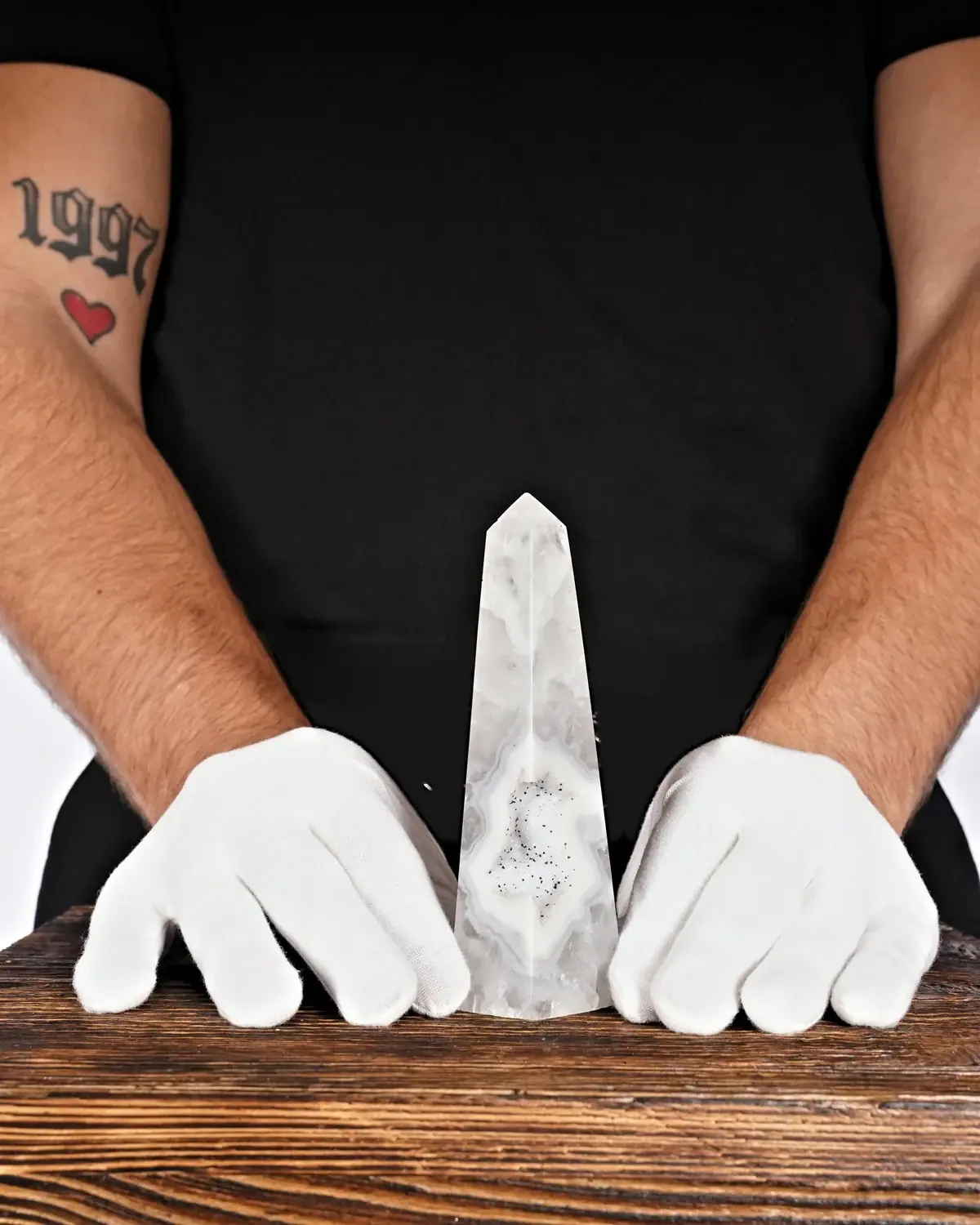 Achat Turm Nr. 7 in weiss behandschuhten Händen