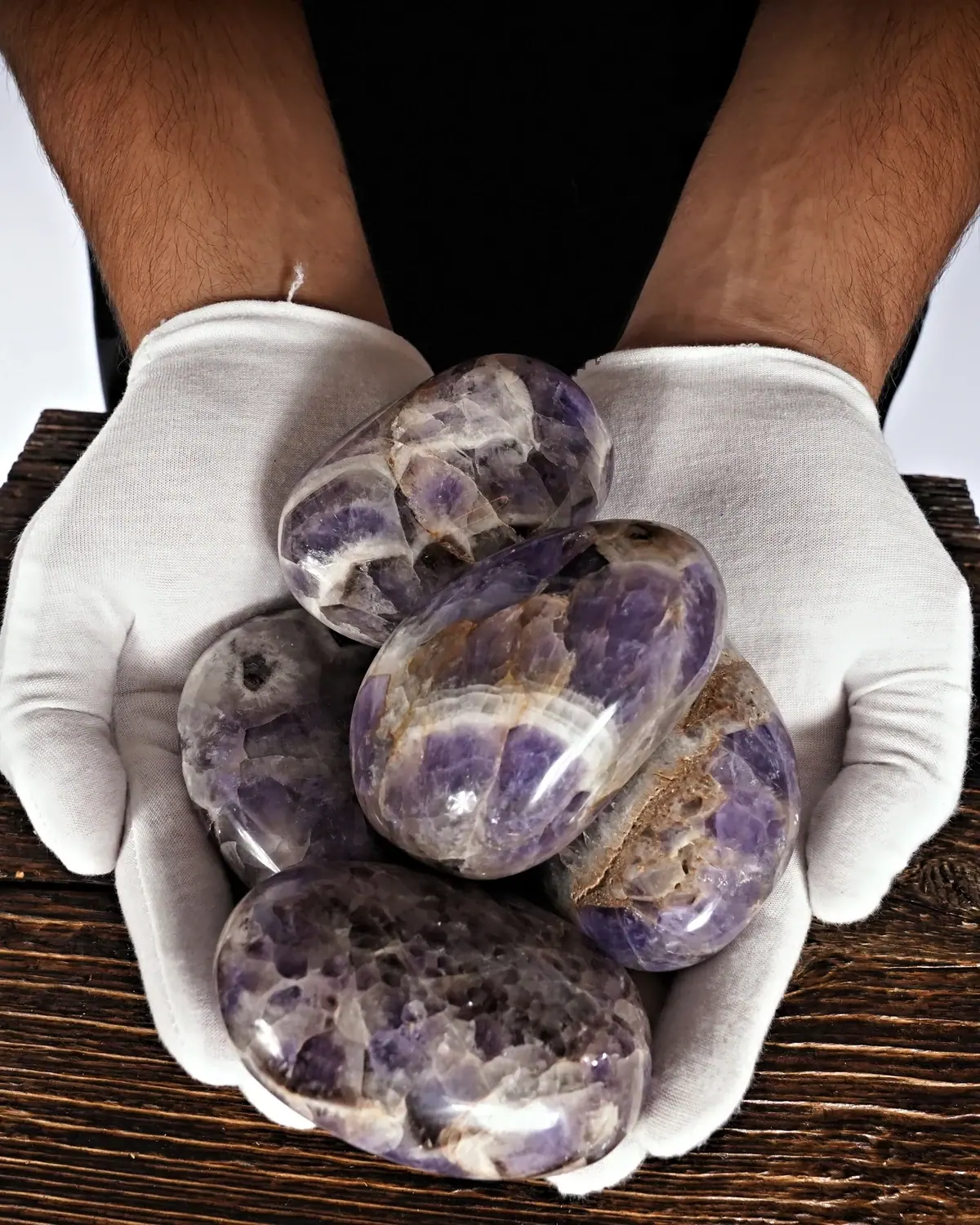 Handschmeichler aus Chevron-Amethyst in weiss behandschuhten Händen