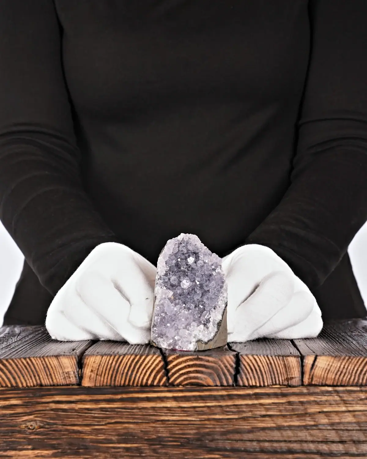 Der seltene und transparente Amethyst-Fels in weiss behandschuhten Händen