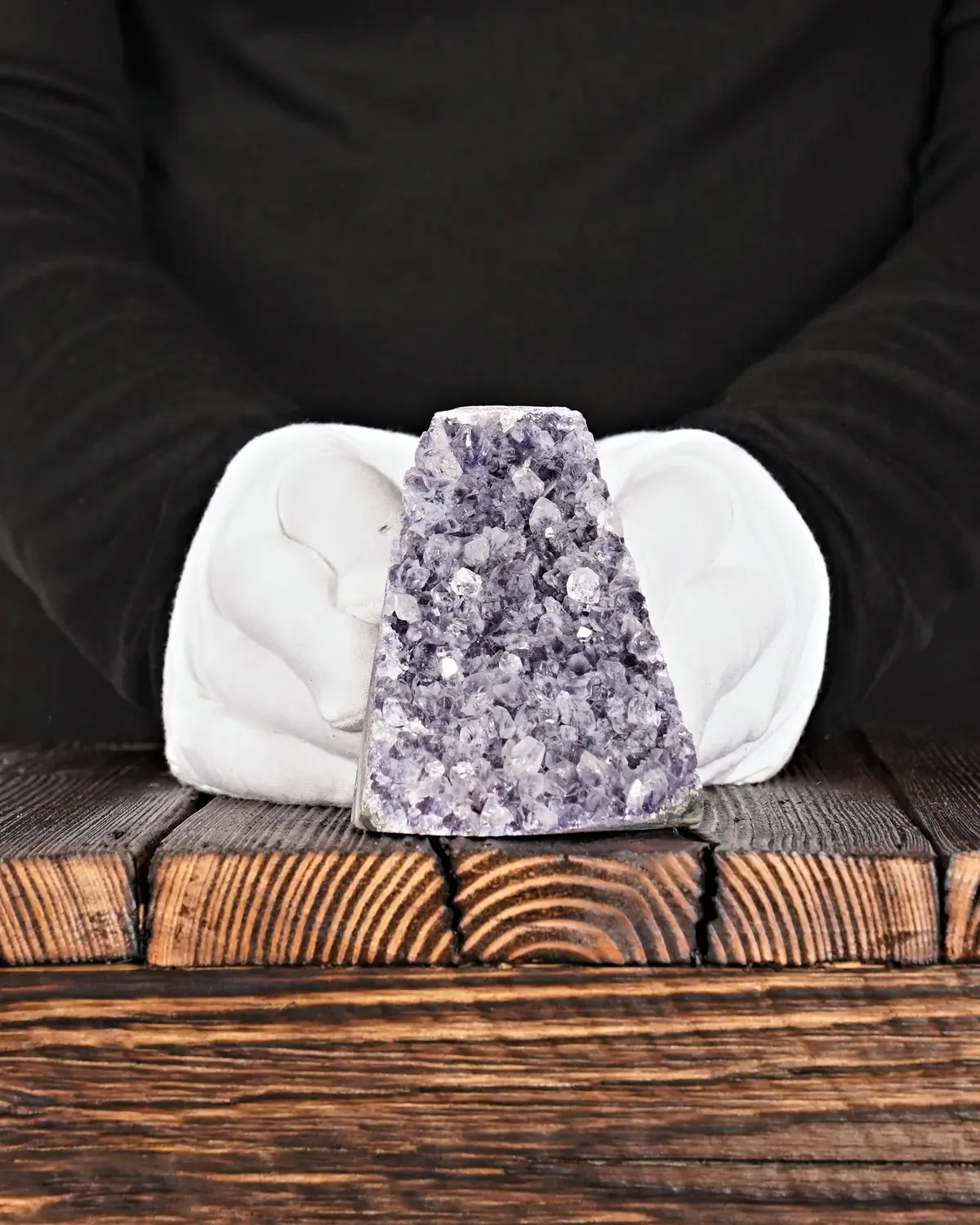 Der Amethyst mit seinem Farbspiel in weiss behandschuhten Händen