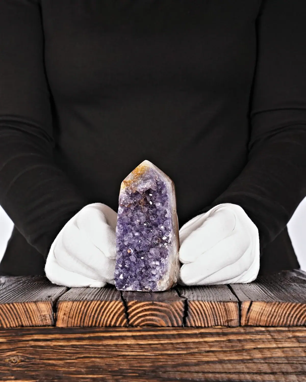 Die Amethyst-Bergspitze in weiss behandschuhten Händen