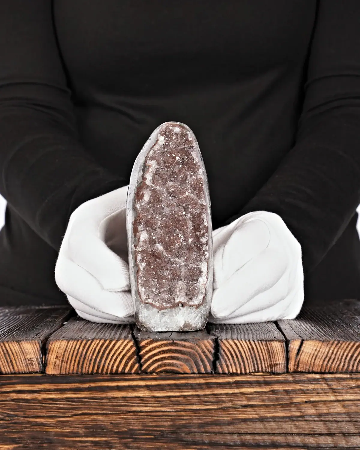 Die Arche Noah mit braunem Amethyst und Bergkristall in weiss behandschuhten Händen