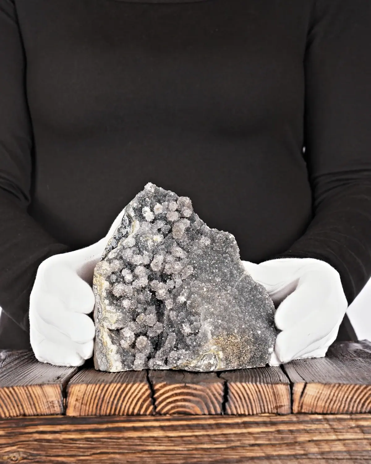 Amethyst Druse Nr. 86 in weiss behandschuhten Händen