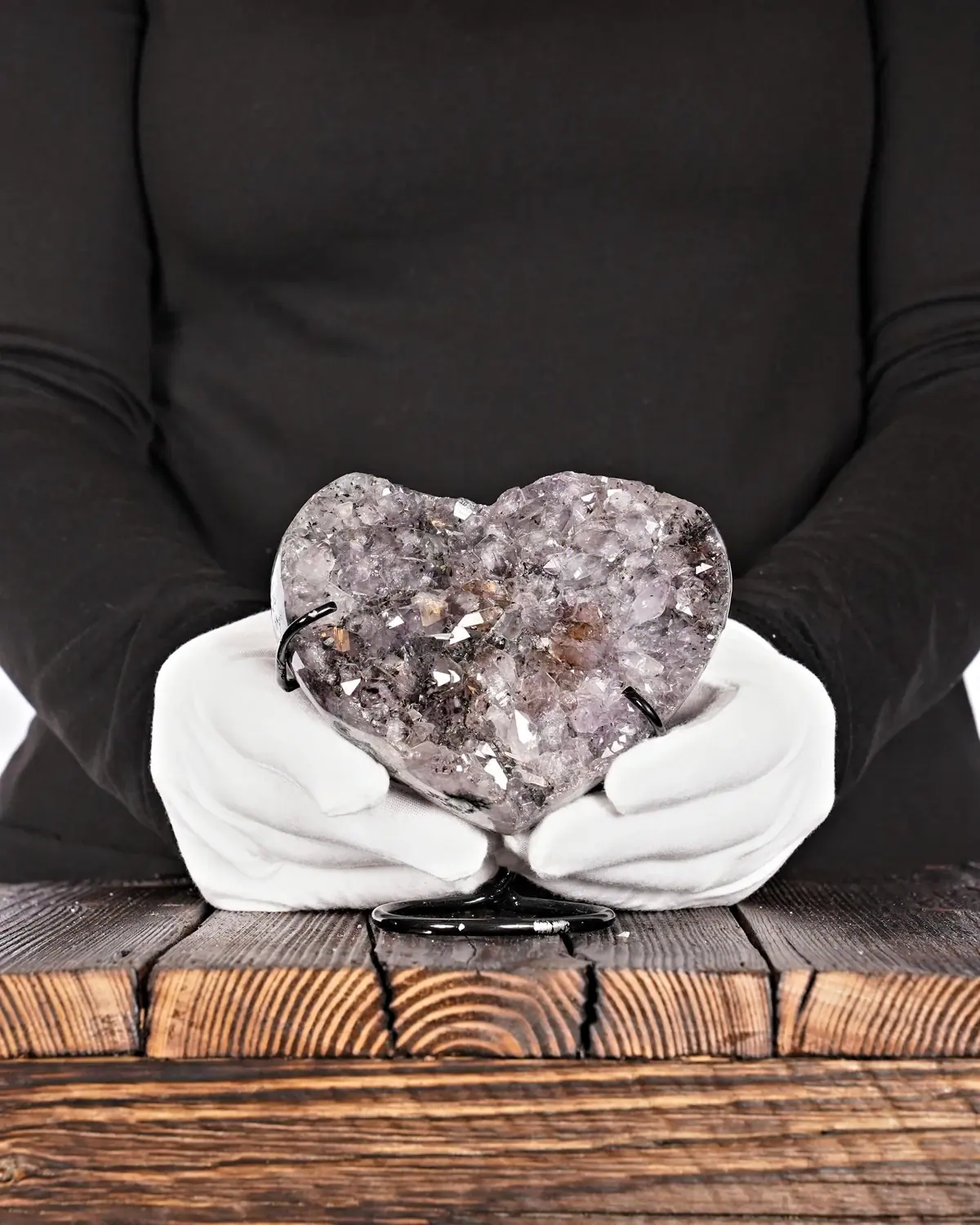 Seltenes graues und brillantes Amethyst-Herz in weiss behandschuhten Händen
