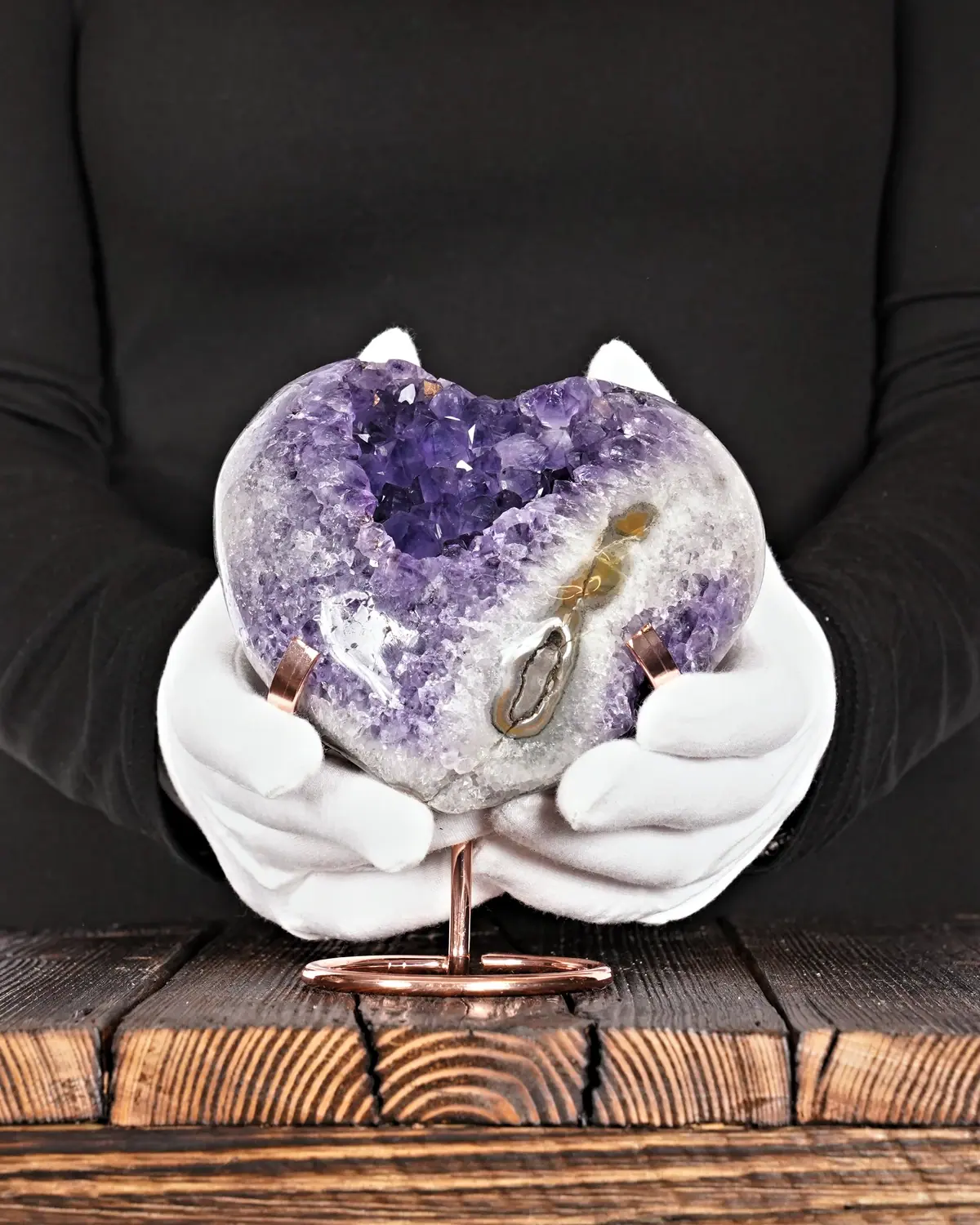 Das reine Amethyst-Herz in weiss behandschuhten Händen