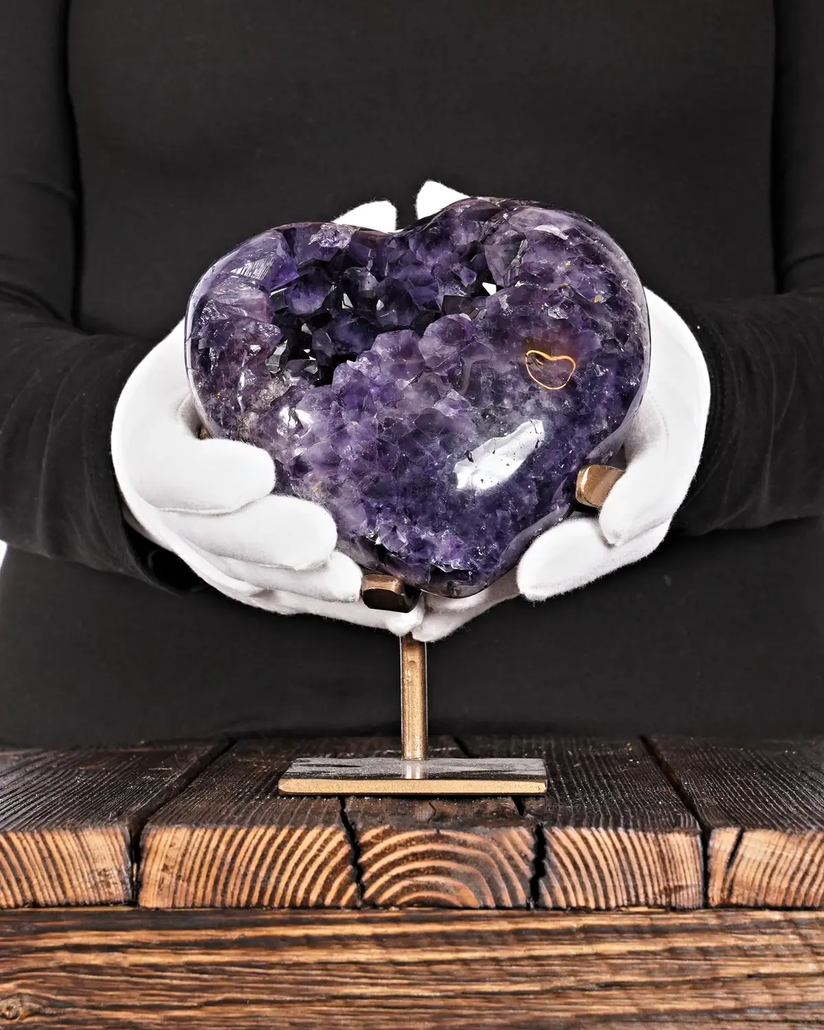 Das strahlende Amethyst Herz in weiss behandschuhten Händen