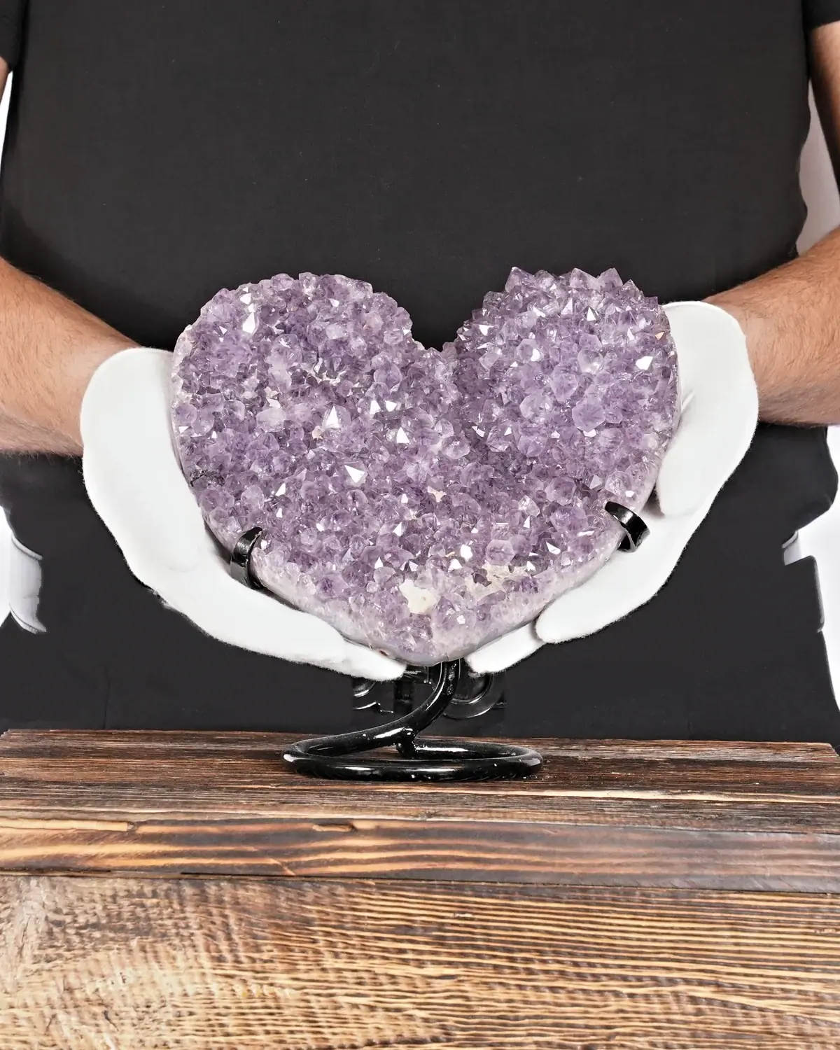 Das Kaktus-Amethyst-Herz aus Brasilien in weiss behandschuhten Händen