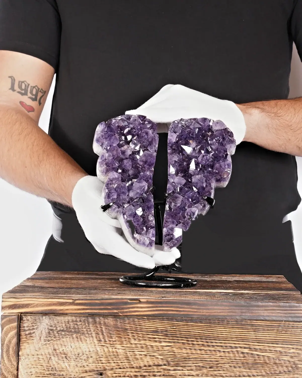 Der brillante Amethyst-Flügel in weiss behandschuhten Händen