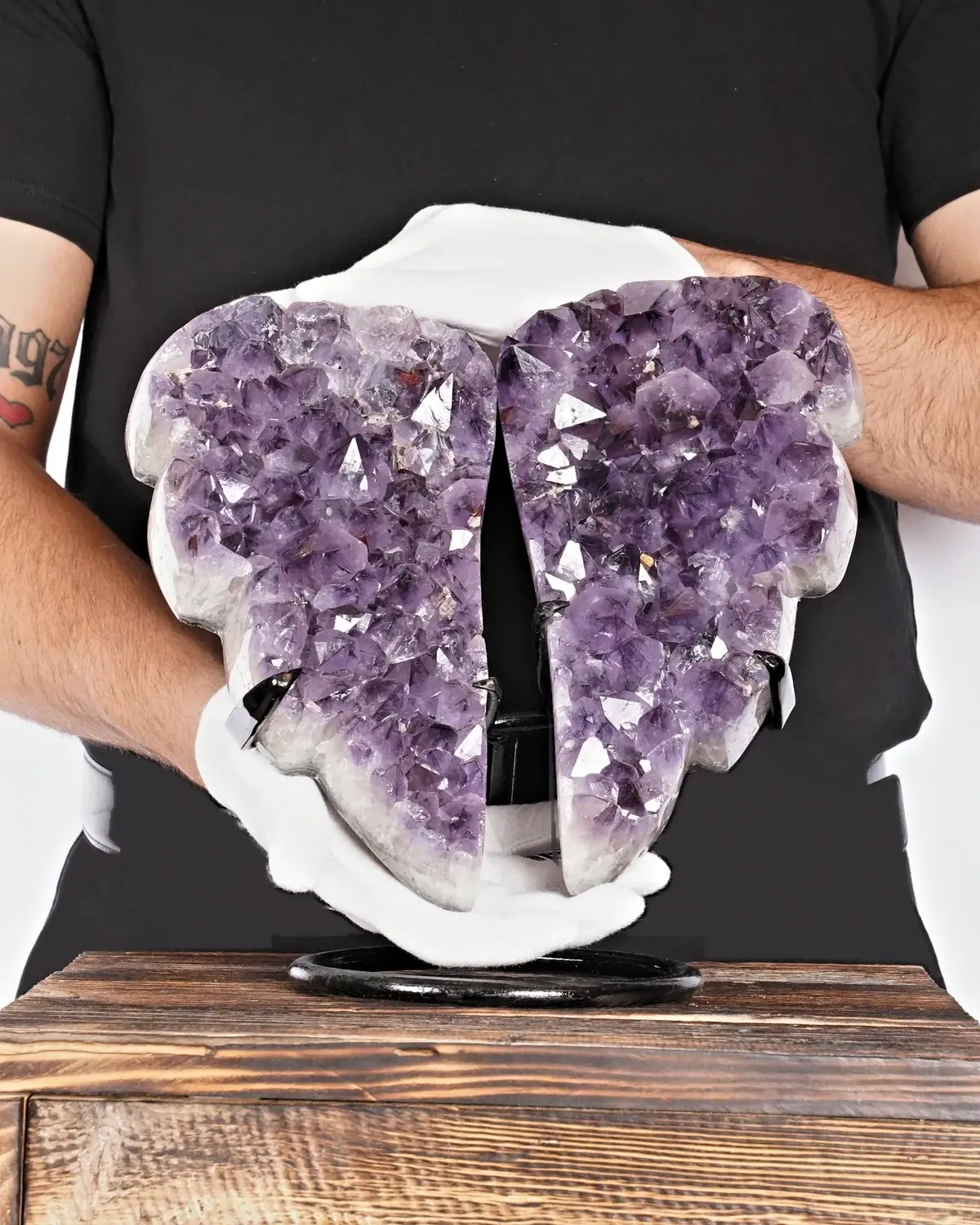 Der beruhigende Amethyst-Flügel in weiss behandschuhten Händen