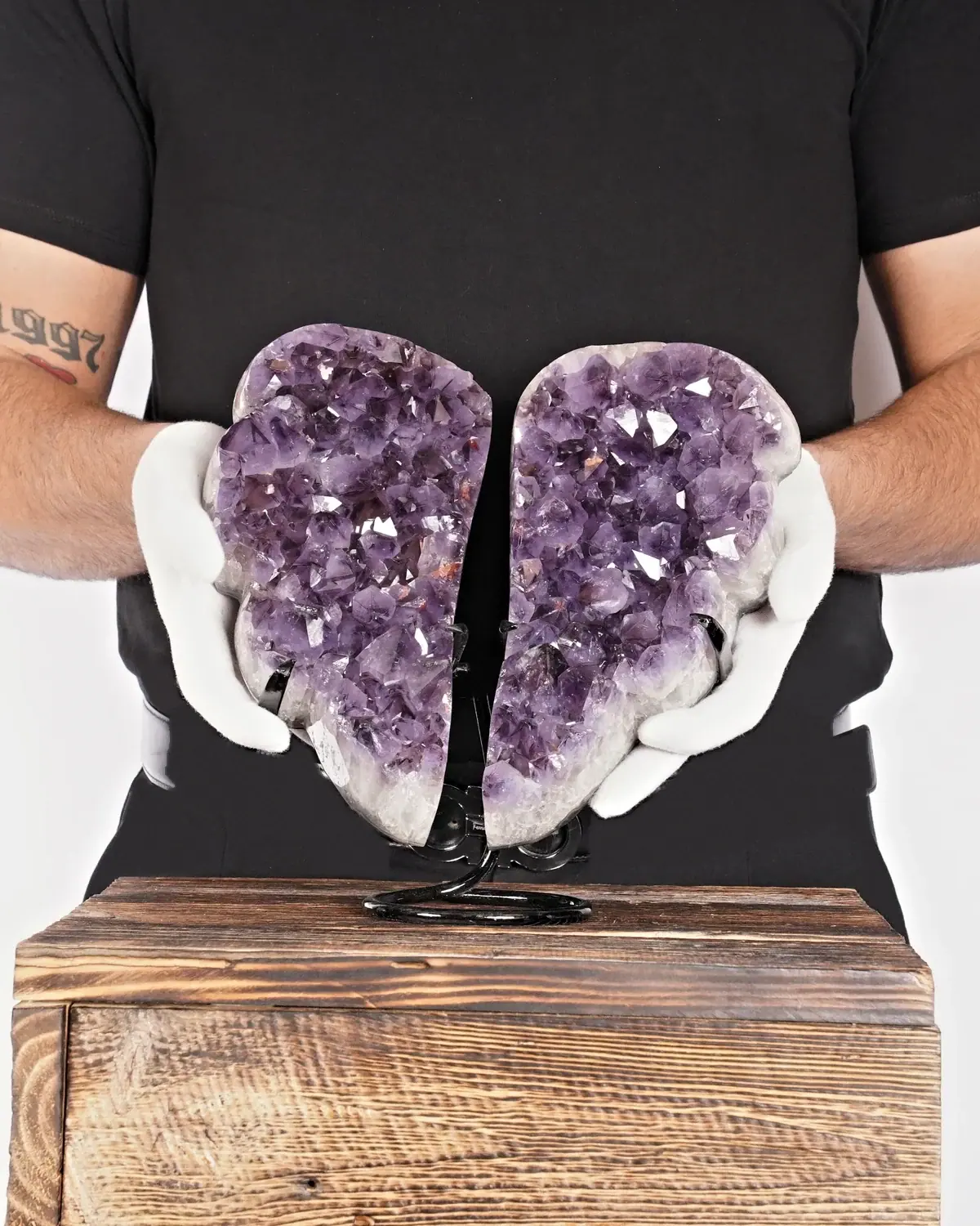 Der beruhigende Amethyst-Flügel in weiss behandschuhten Händen