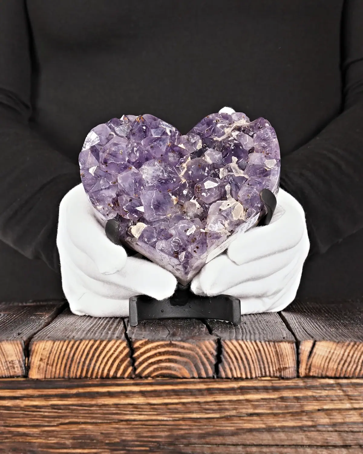 Das Amethyst-Herz mit der Calcit-Landschaft in weiss behandschuhten Händen