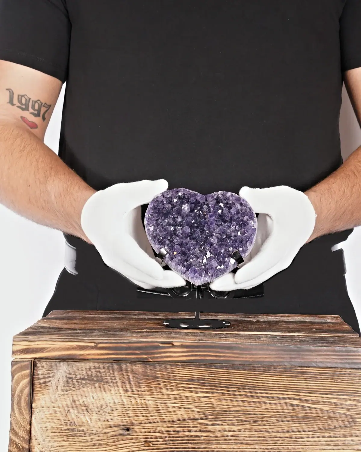 Das glückbringende Amethyst-Herz aus Uruguay in weiss behandschuhten Händen