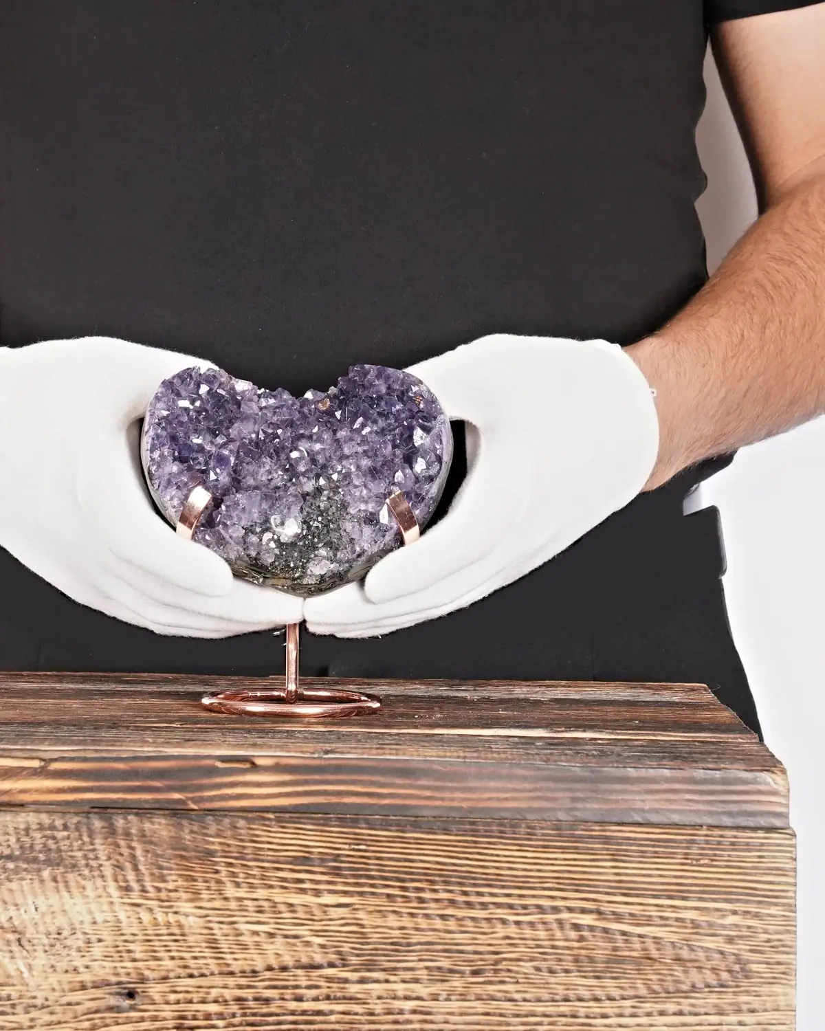 Das geschwungene Amethyst-Flügel-Herz in weiss behandschuhten Händen