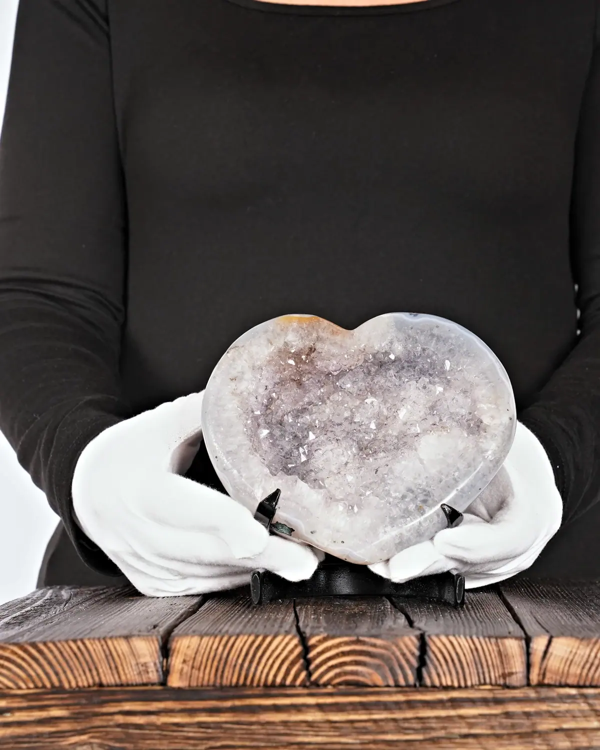 Amethyst-Bergkristall-Drusen-Herz aus Brasilien in weiss behandschuhten Händen