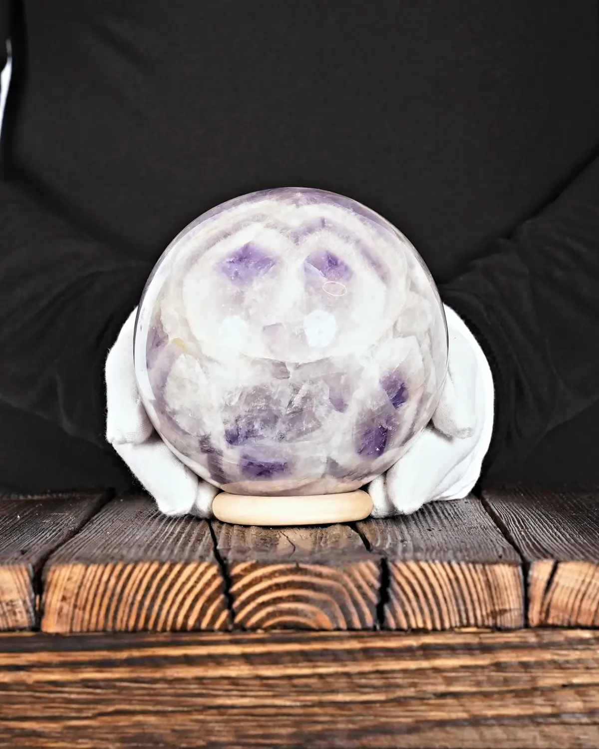 Die Eulen-Zwillinge aus Chevron-Amethyst in weiss behandschuhten Händen