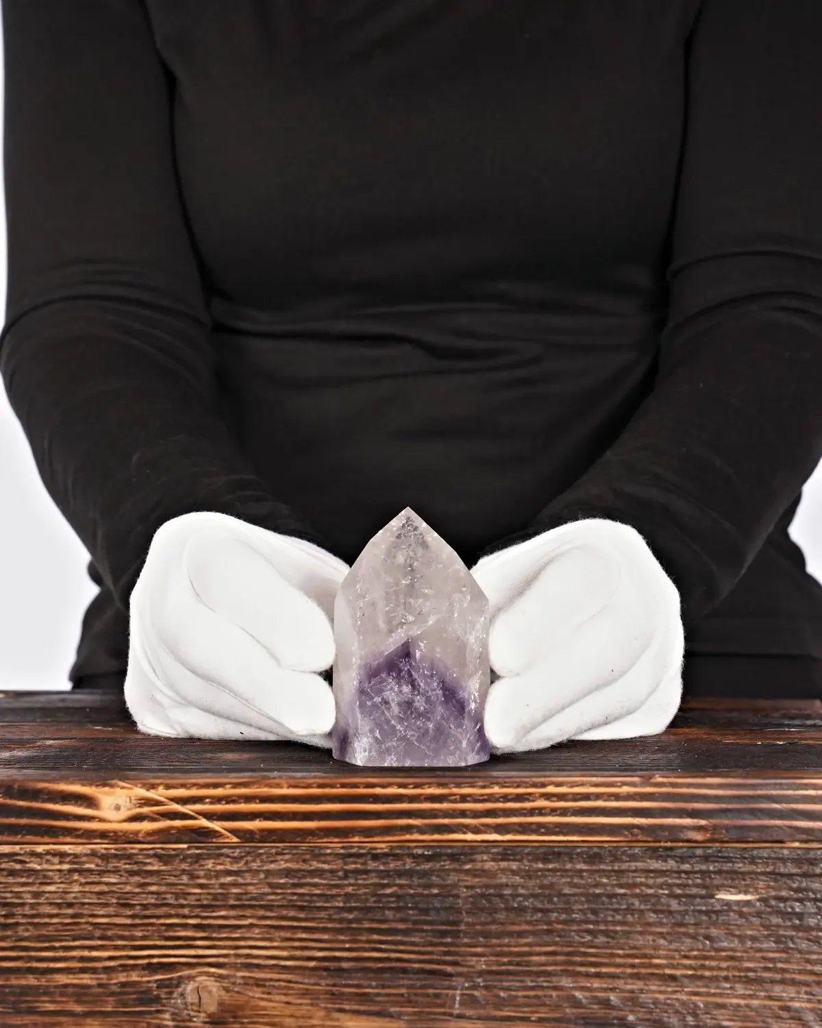 Die Amethyst-Bergkristall-Spitze mit Phantom in weiss behandschuhten Händen