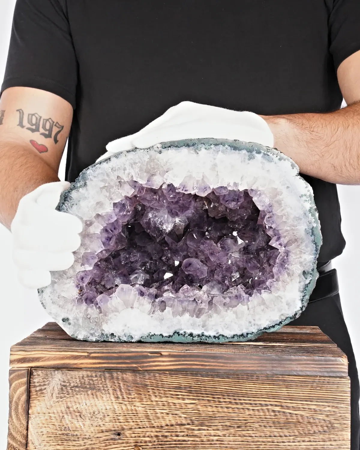 Die mystische Amethyst-Geode in weiss behandschuhten Händen