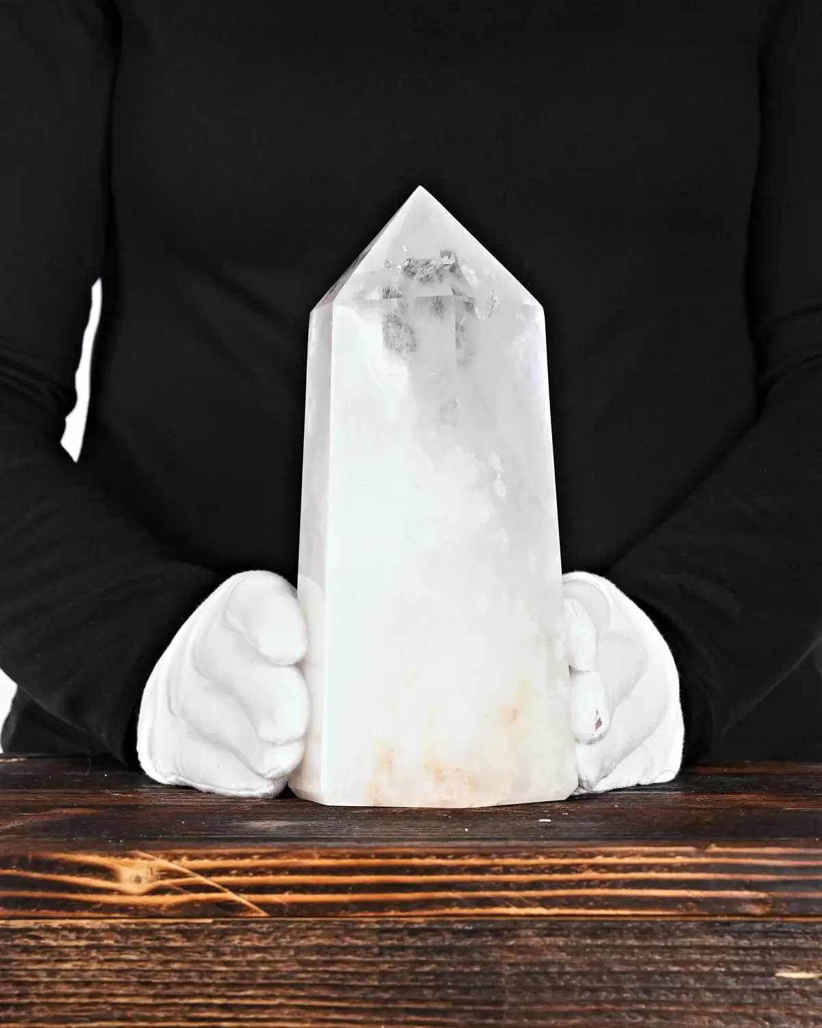 Die kraftvolle Bergkristallspitze in weiss behandschuhten Händen