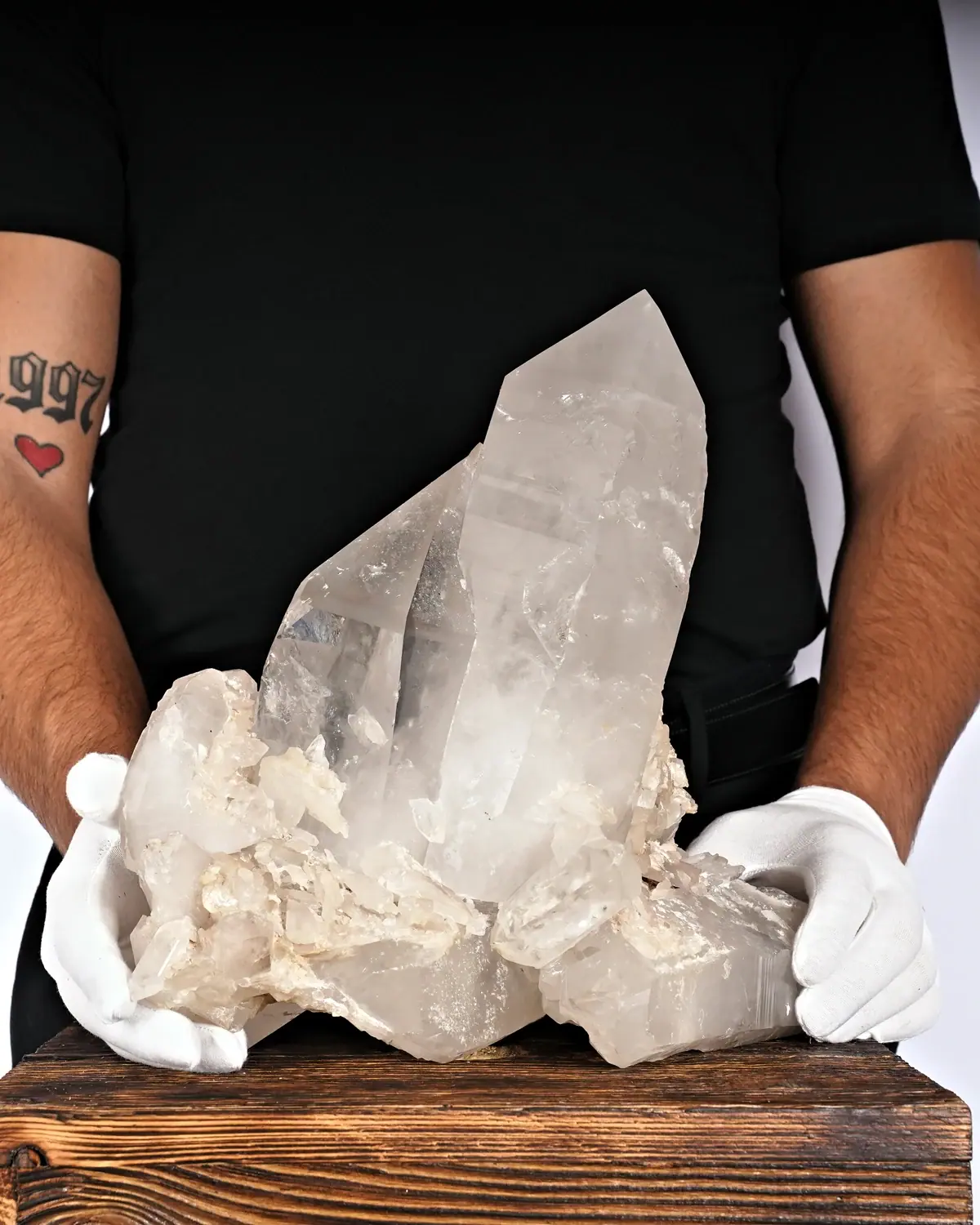 Bergkristall Gruppe Nr. 18 in weiss behandschuhten Händen