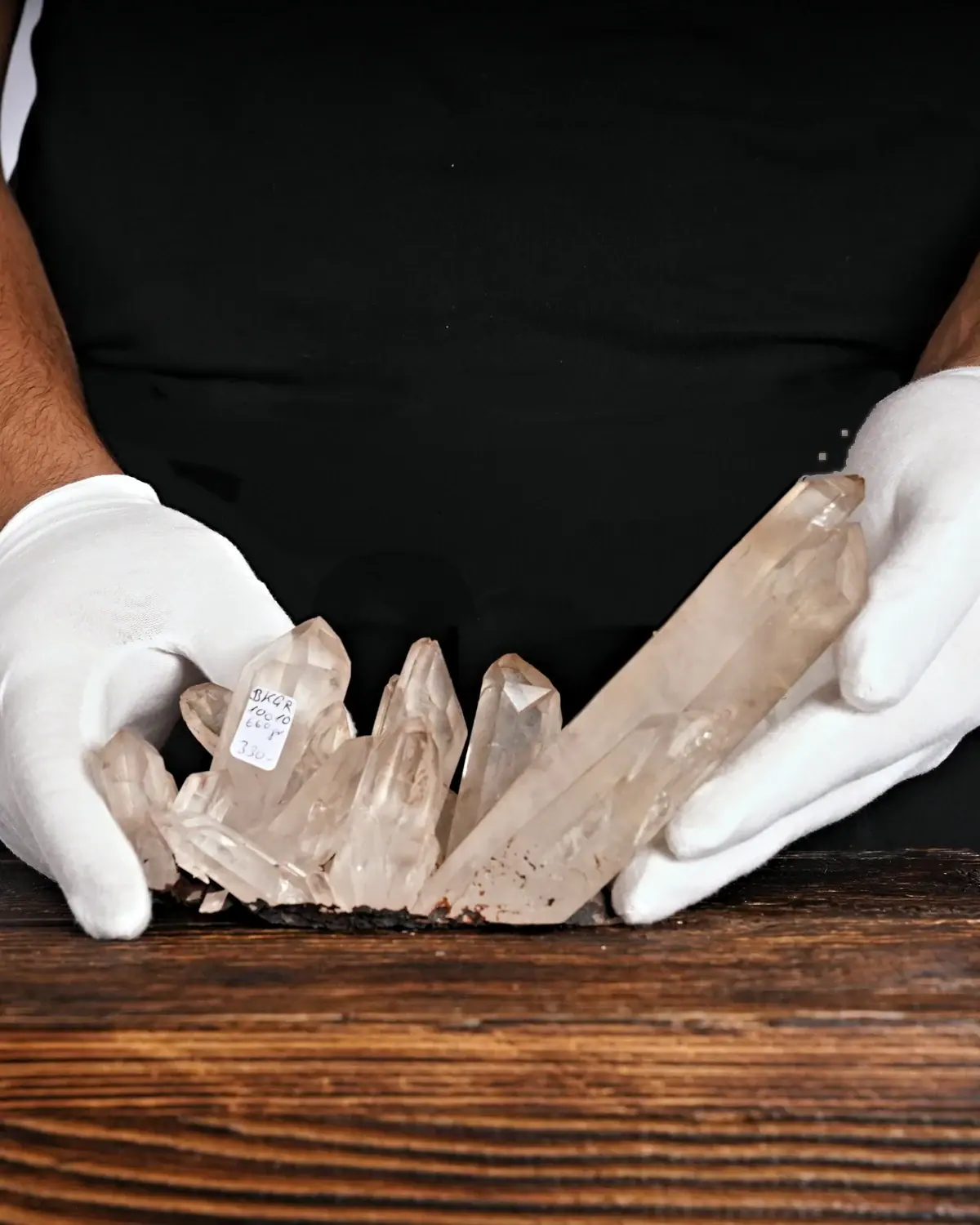 Die Bergkristallstufe mit den mächtigen Drillingsspitzen in weiss behandschuhten Händen