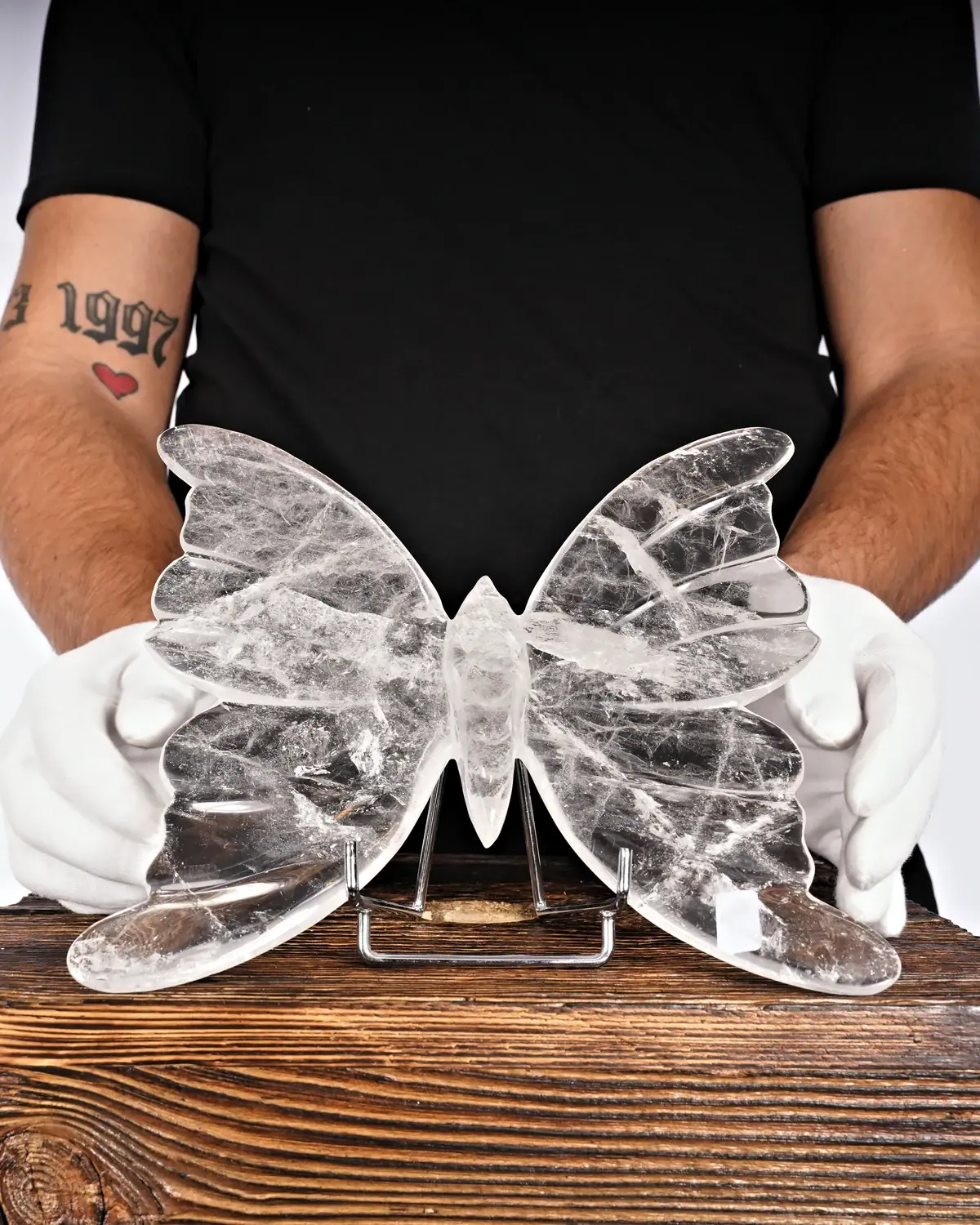 Bergkristall Schmetterling Nr. 51 in weiss behandschuhten Händen
