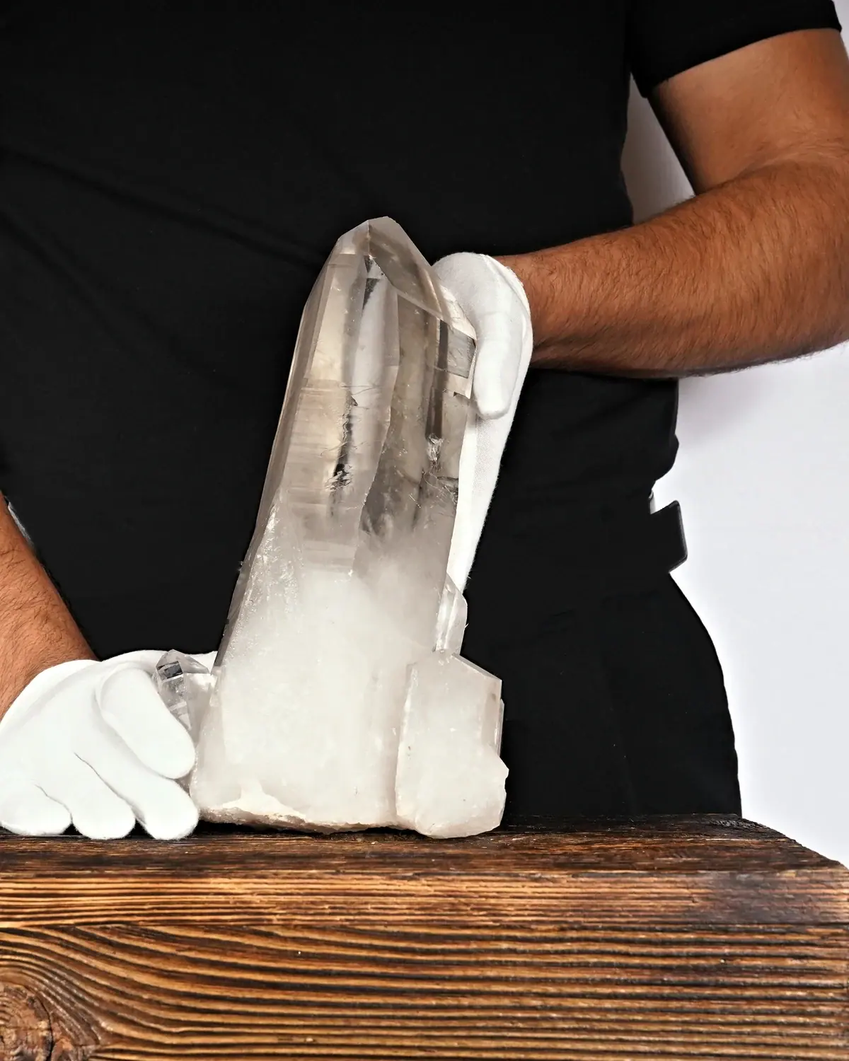Bergkristall Spitze Nr. 53 in weiss behandschuhten Händen