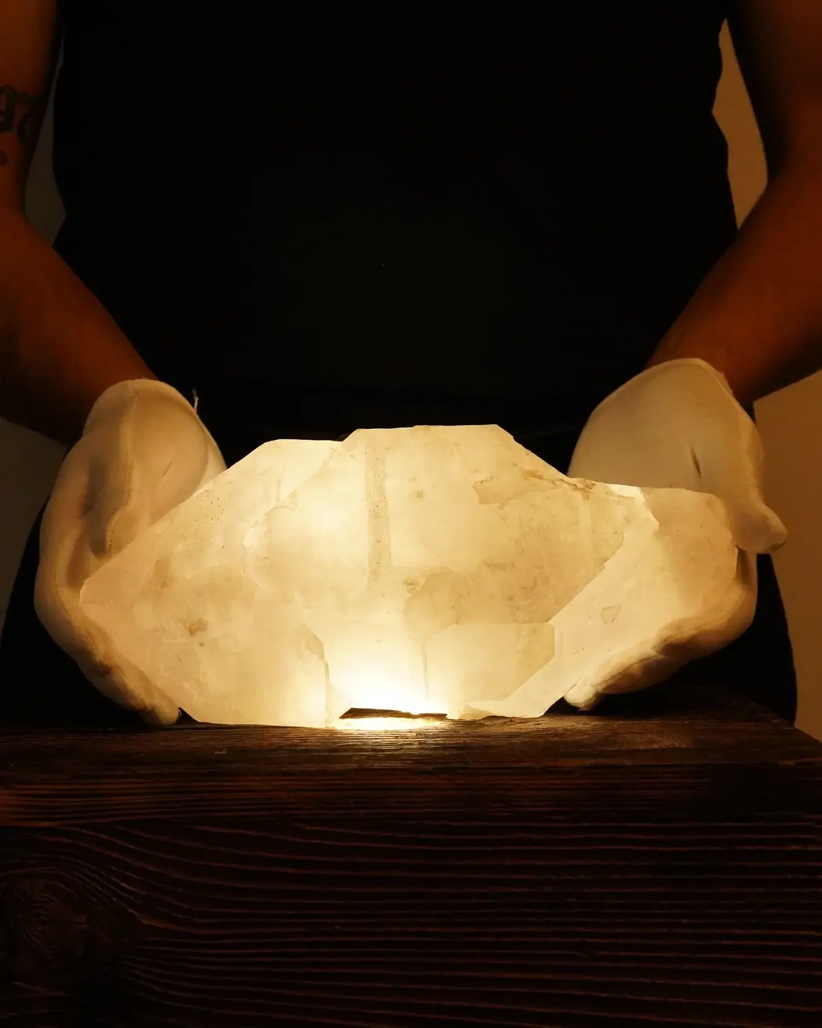 Der seltene Bergkristall Amethyst Doppelender in weiss behandschuhten Händen