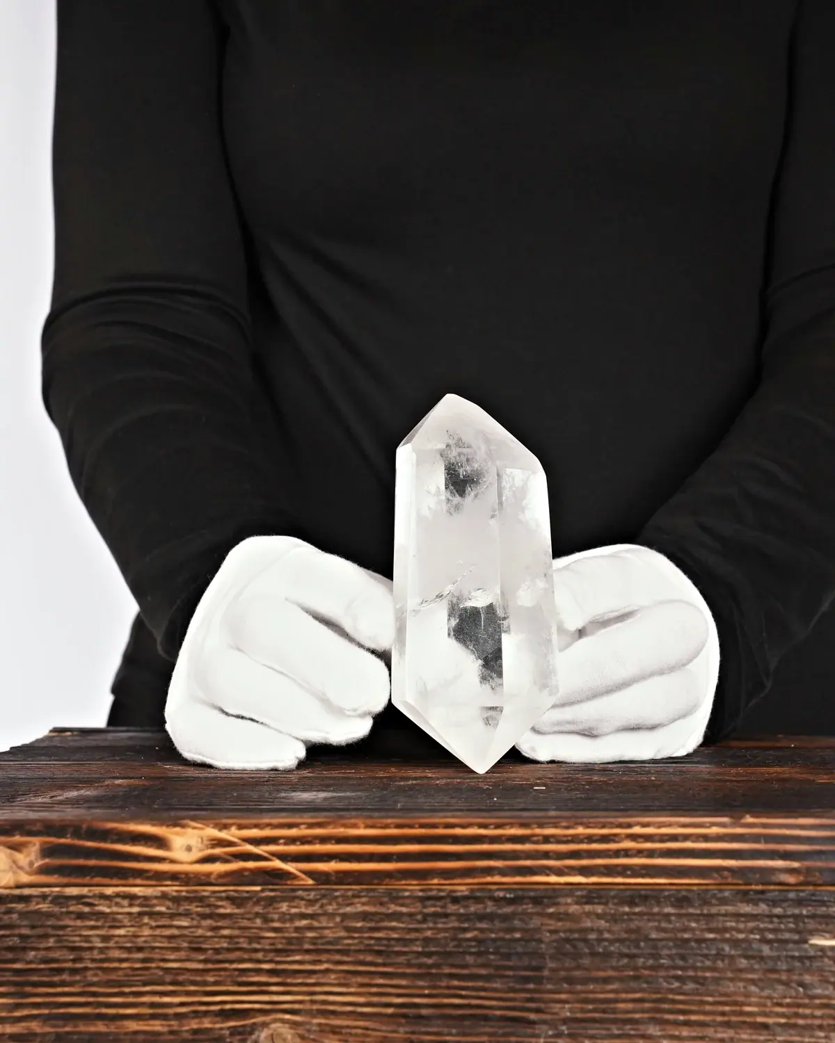Die glasklaren, grossen Doppelender aus lemurischem Bergkristall in weiss behandschuhten Händen