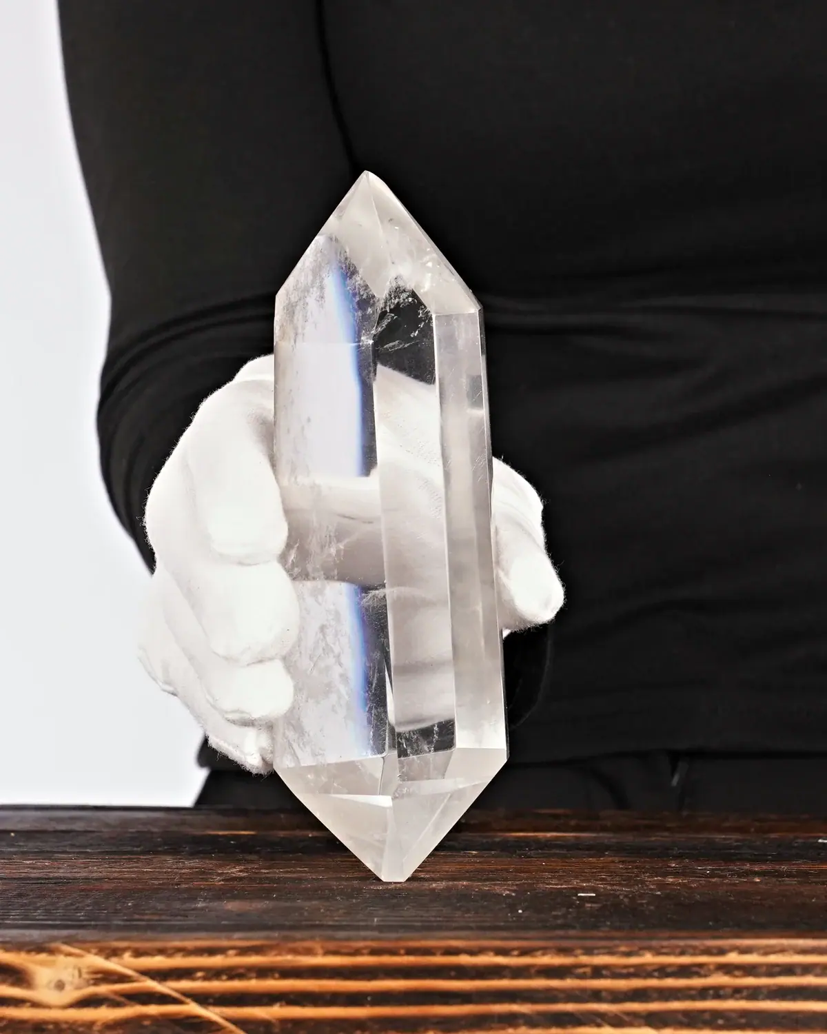 Die glasklaren, grossen Doppelender aus lemurischem Bergkristall in weiss behandschuhten Händen