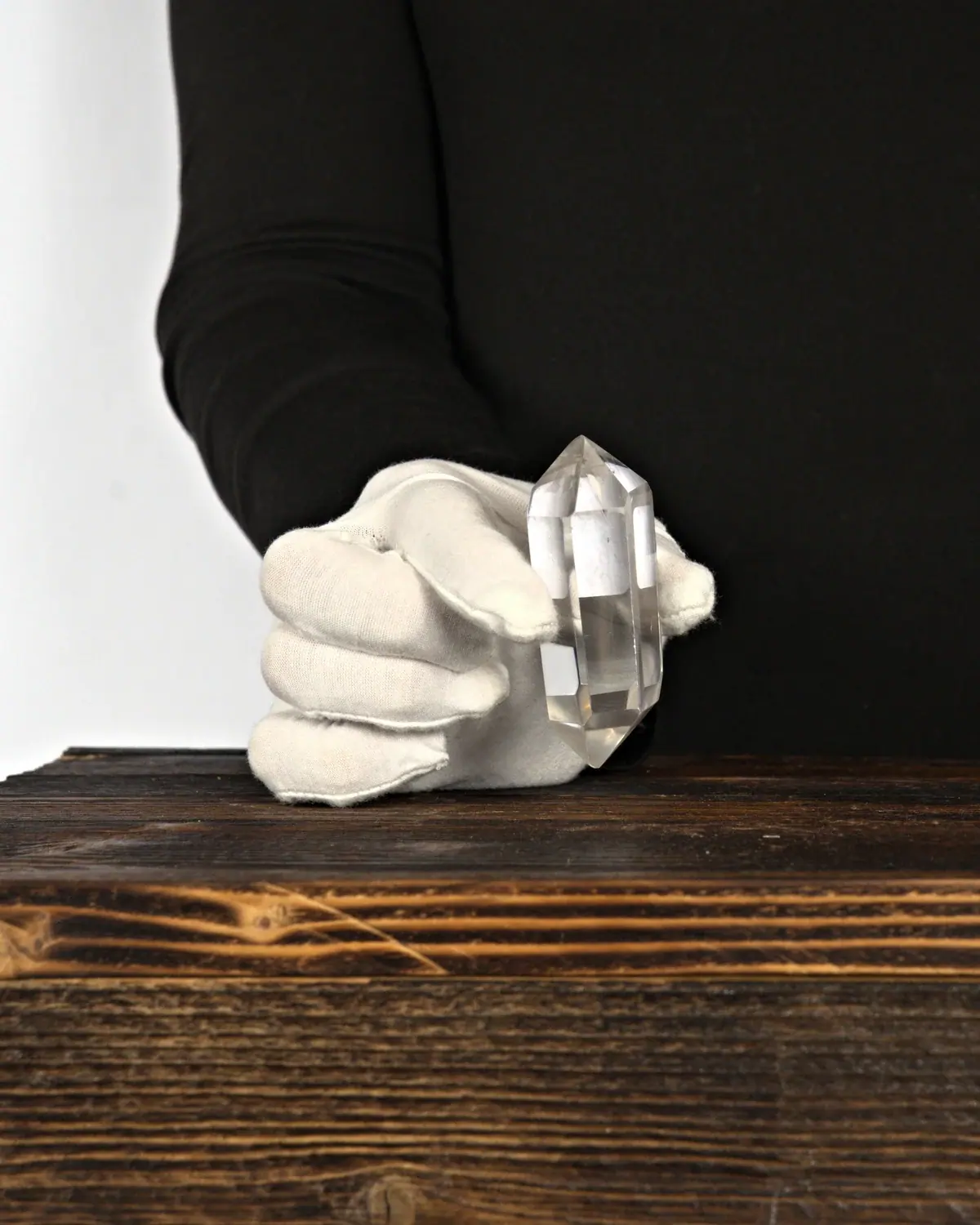 Die glasklaren Doppelender aus lemurischem Bergkristall in weiss behandschuhten Händen