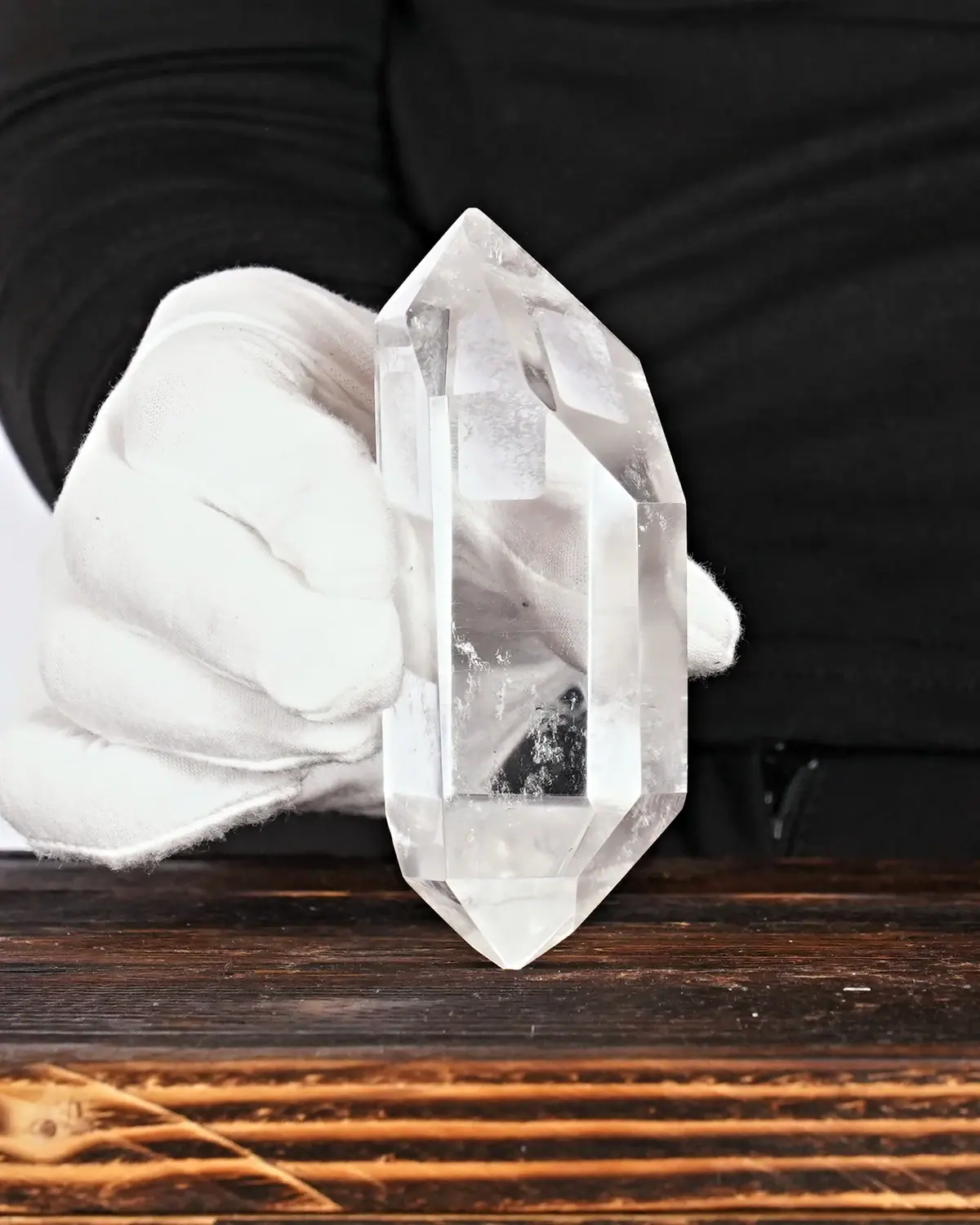 Die glasklaren Doppelender aus lemurischem Bergkristall in weiss behandschuhten Händen