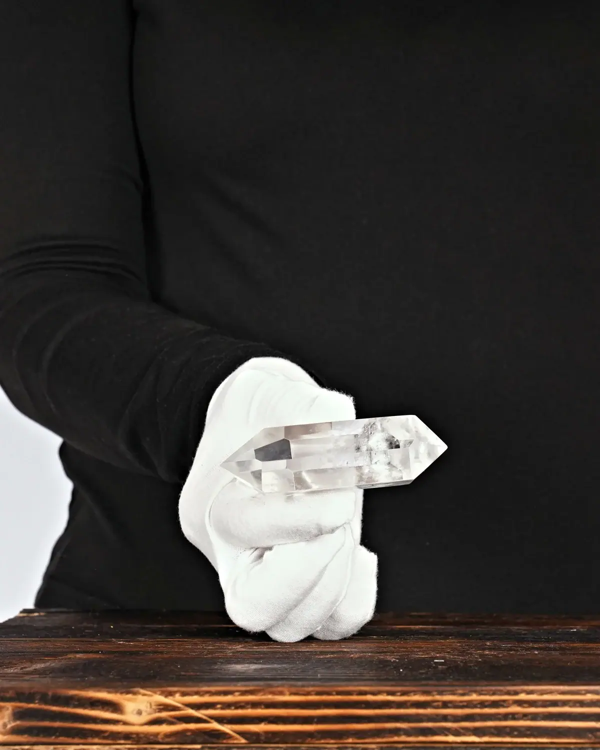Die glasklaren Doppelender aus lemurischem Bergkristall in weiss behandschuhten Händen