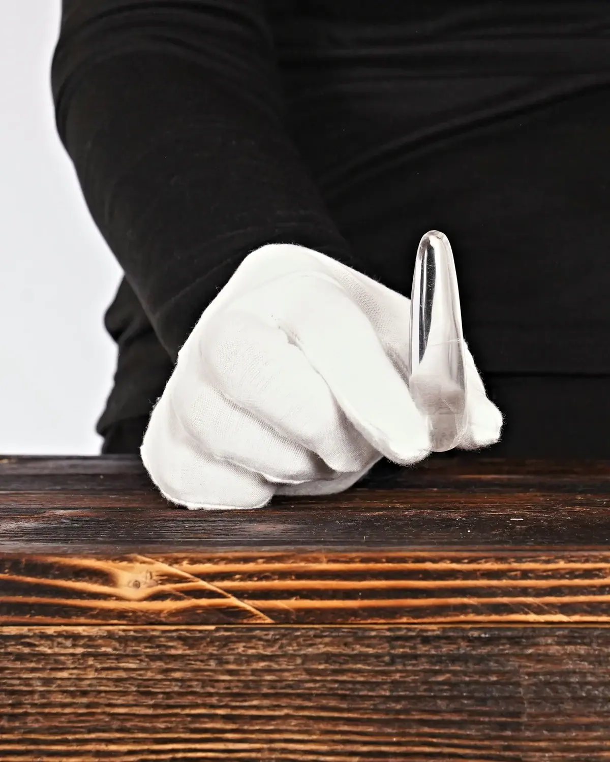 Die kleinen, klaren Bergkristall-Massagestäbe in weiss behandschuhten Händen