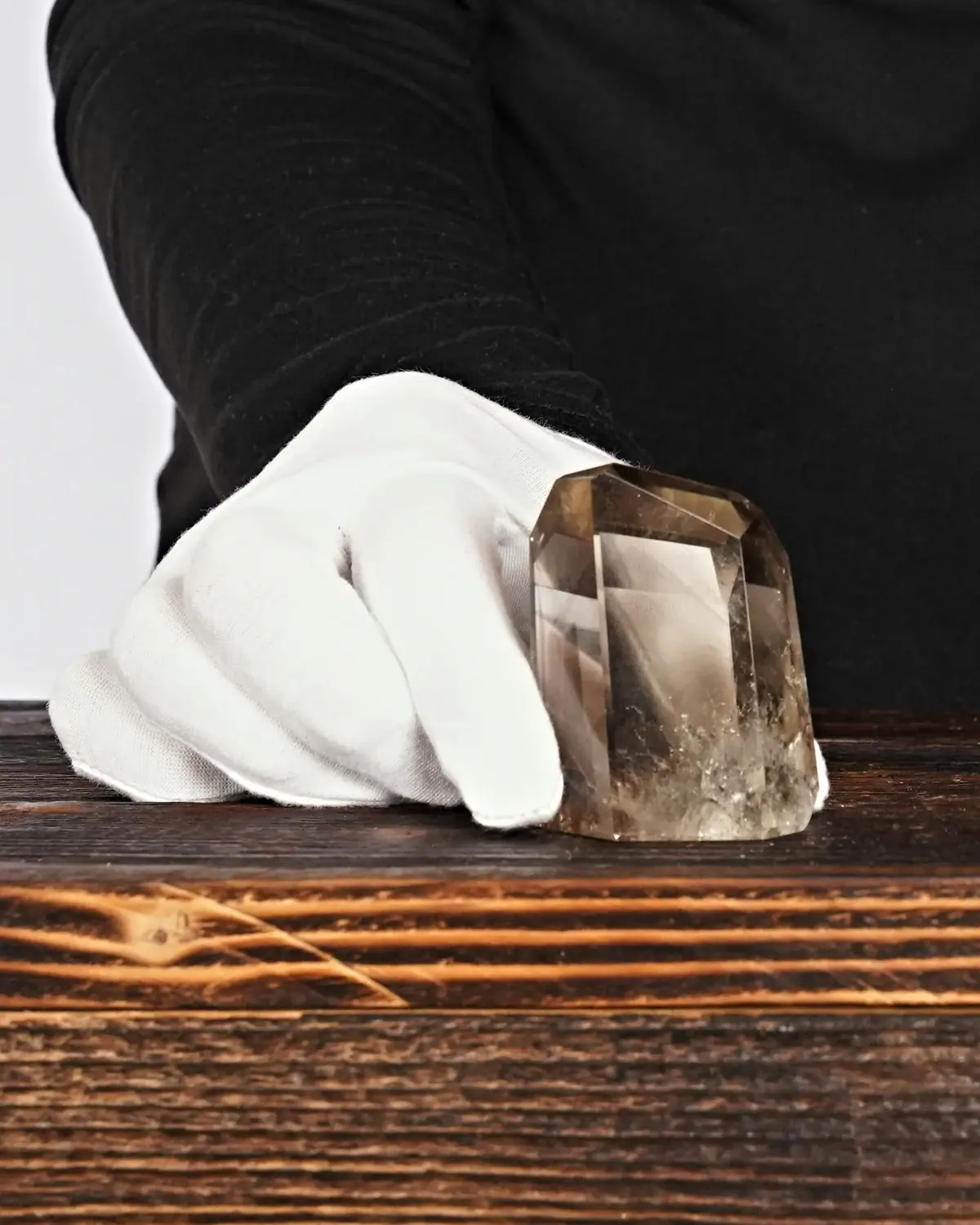Rauchquarz Freiform Nr. 270 in weiss behandschuhten Händen