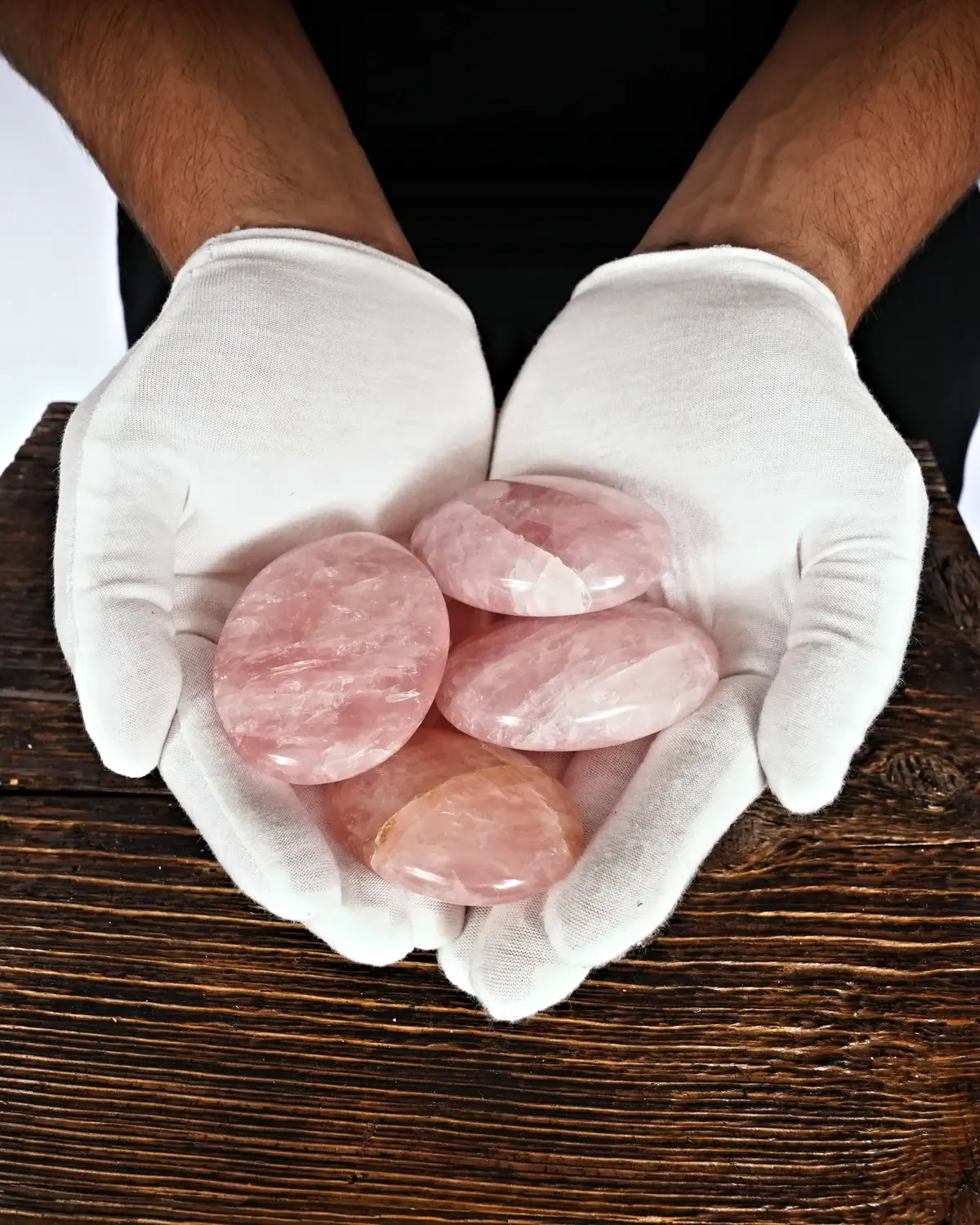Rosenquarz-Handschmeichler in weiss behandschuhten Händen