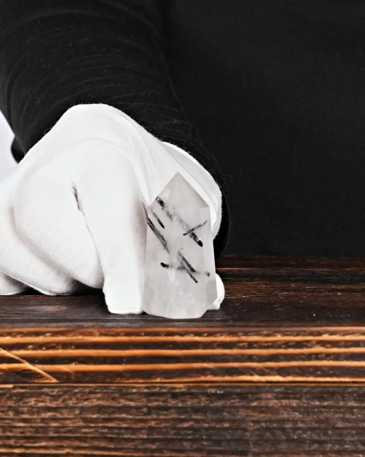 Turmalinquarz Spitze Nr. 24 in weiss behandschuhten Händen