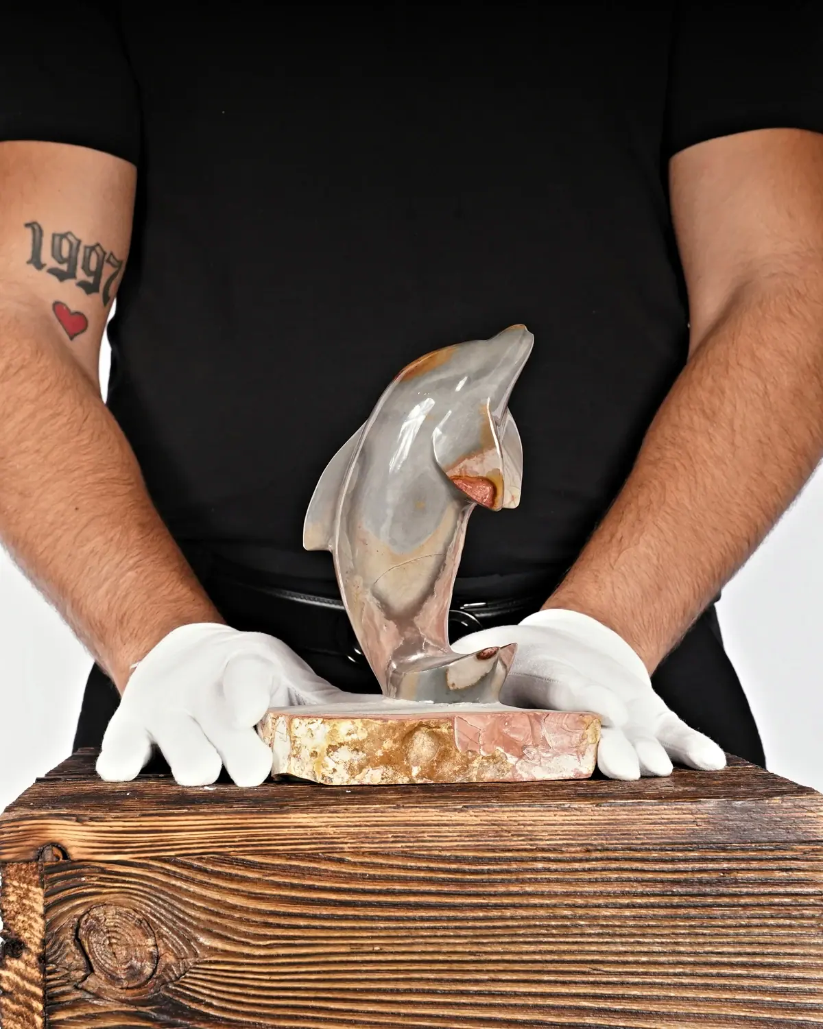 Jaspis Delfin Nr. 4 in weiss behandschuhten Händen